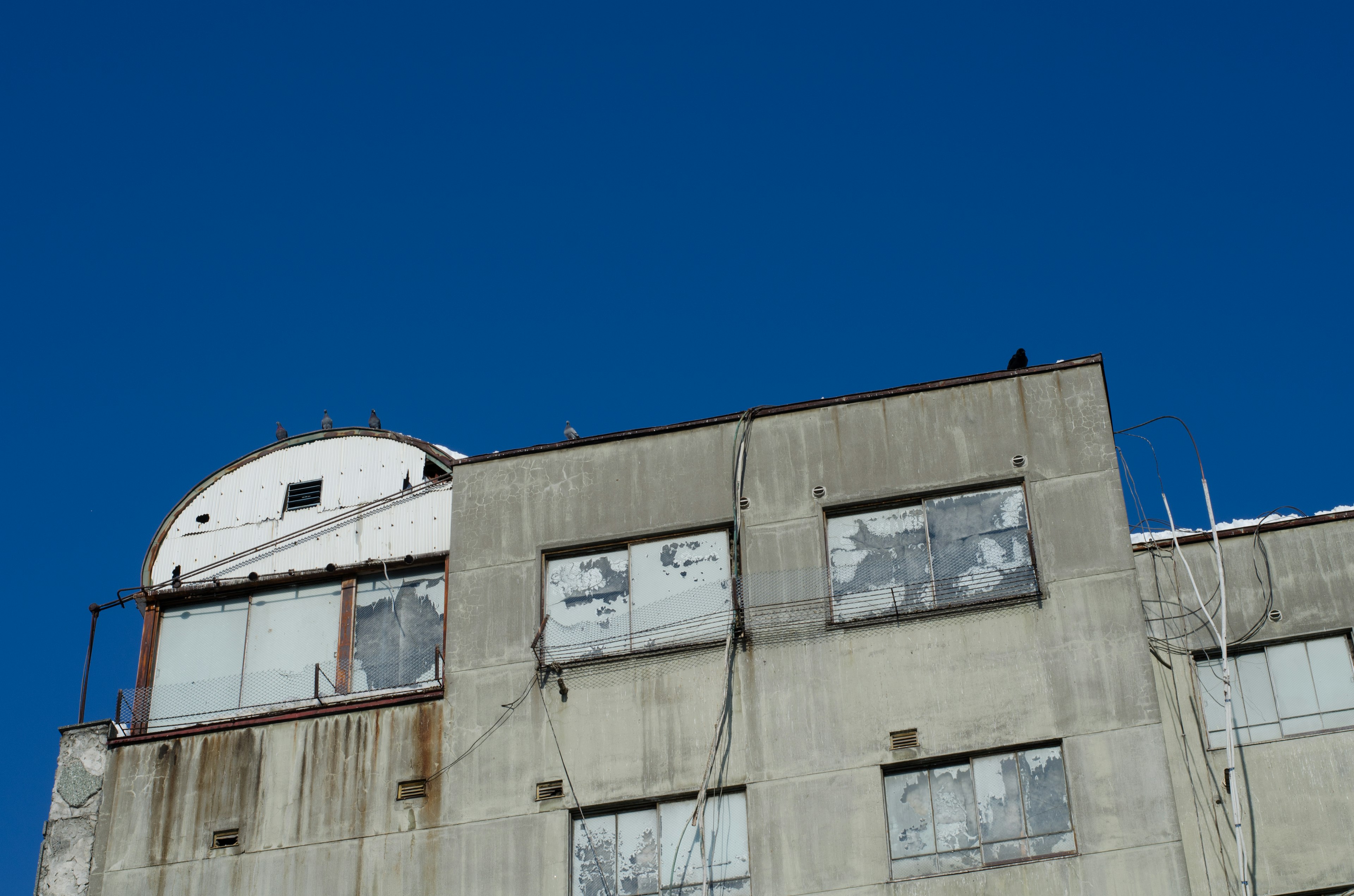 Partie supérieure d'un ancien bâtiment en béton contre un ciel bleu