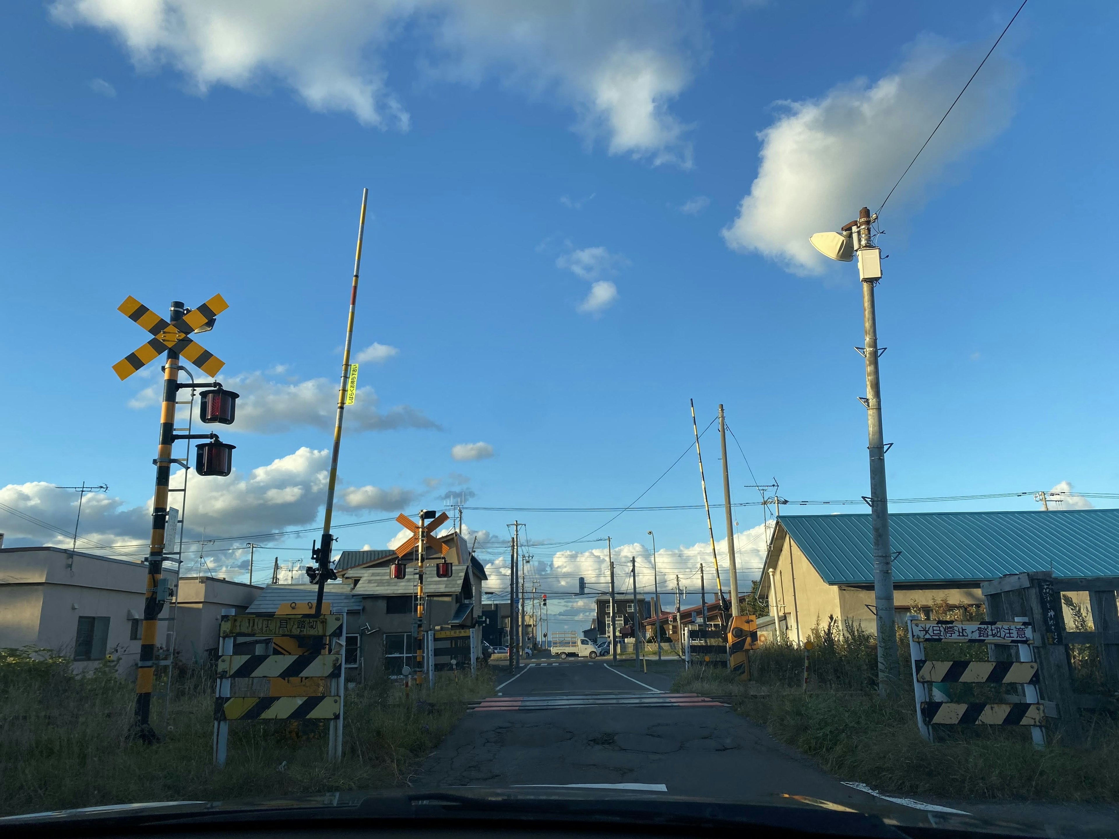 Railroad crossing and signals under a blue sky