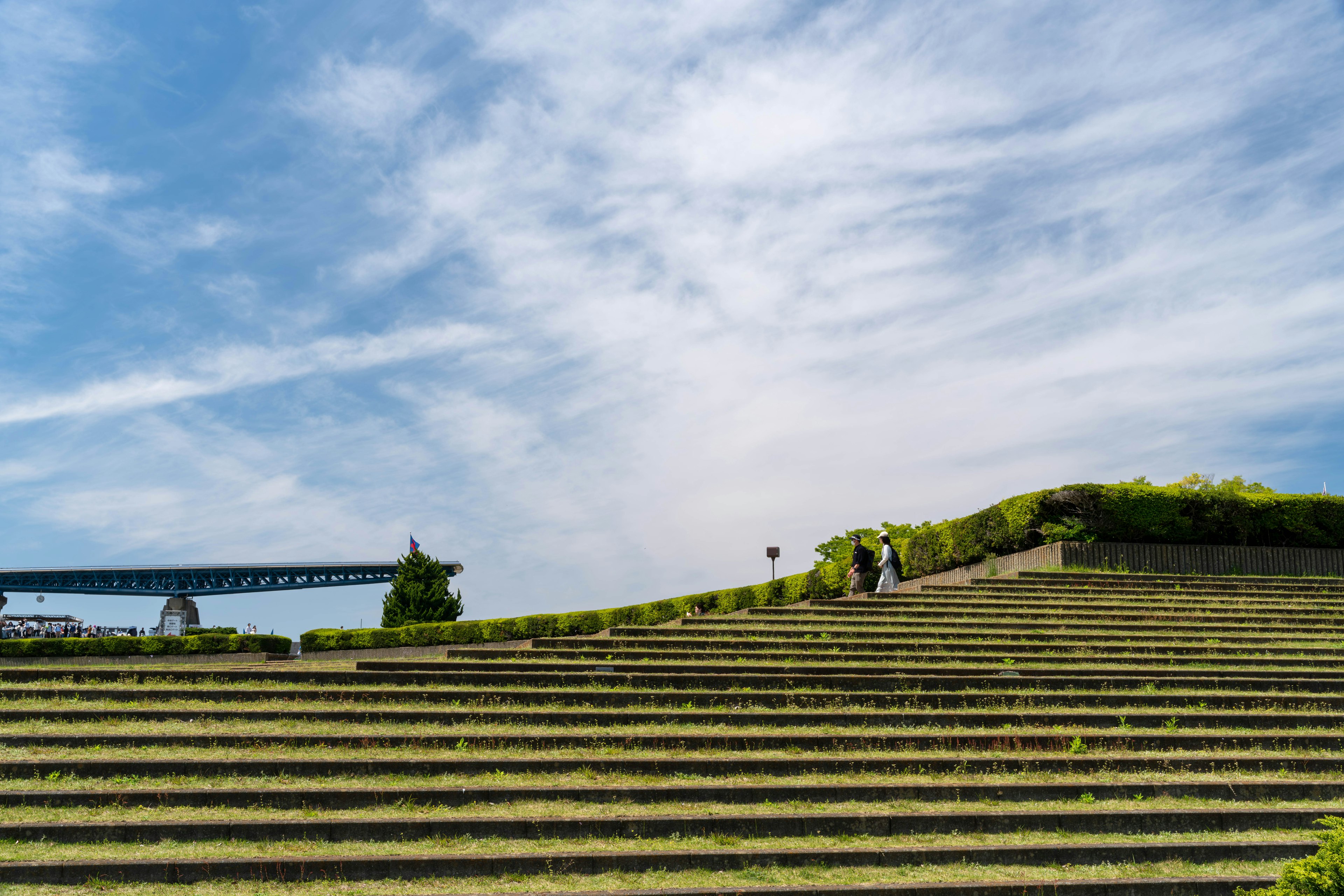 Terraced fields under a blue sky with people