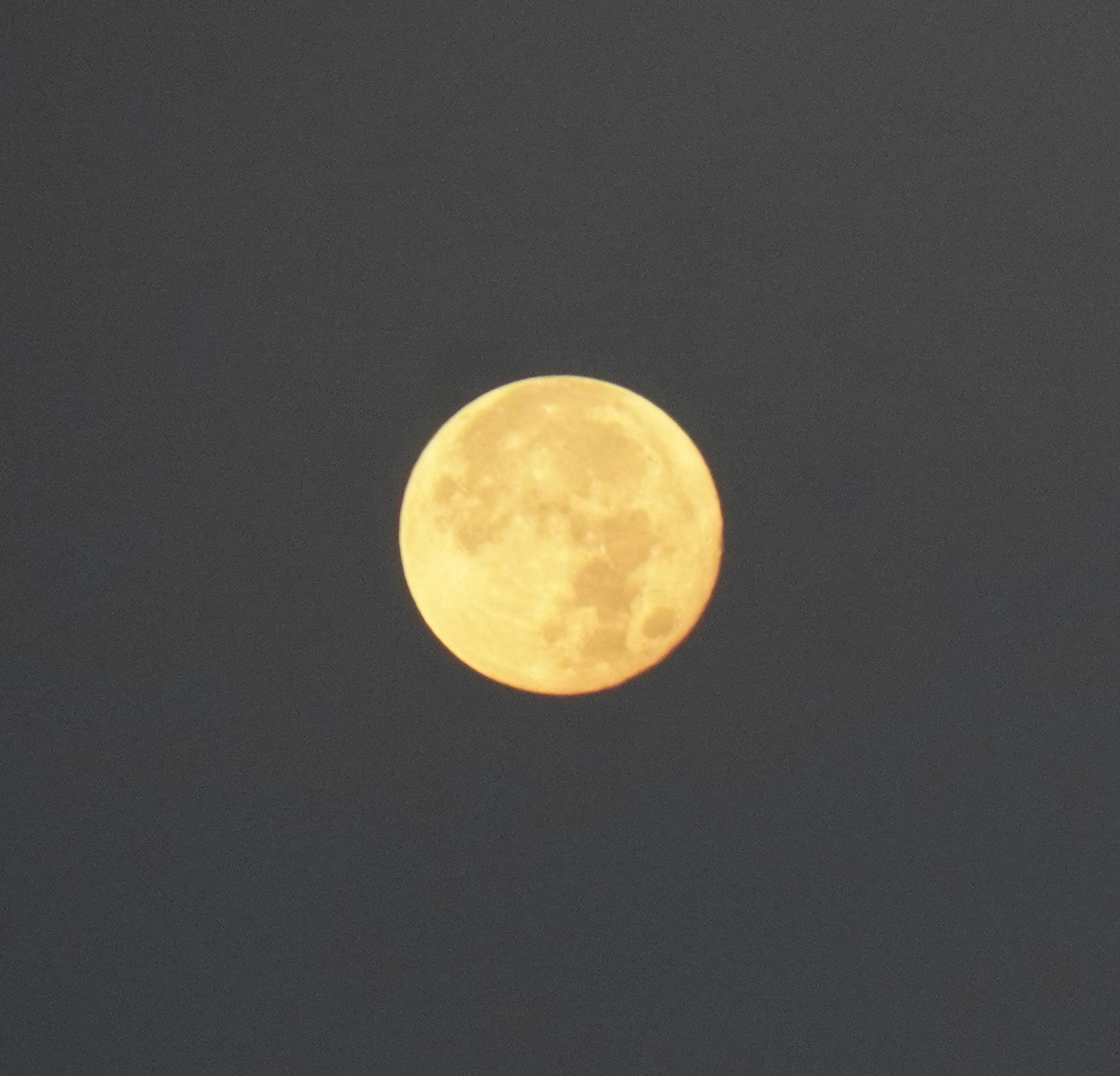 Bright yellow full moon in the night sky