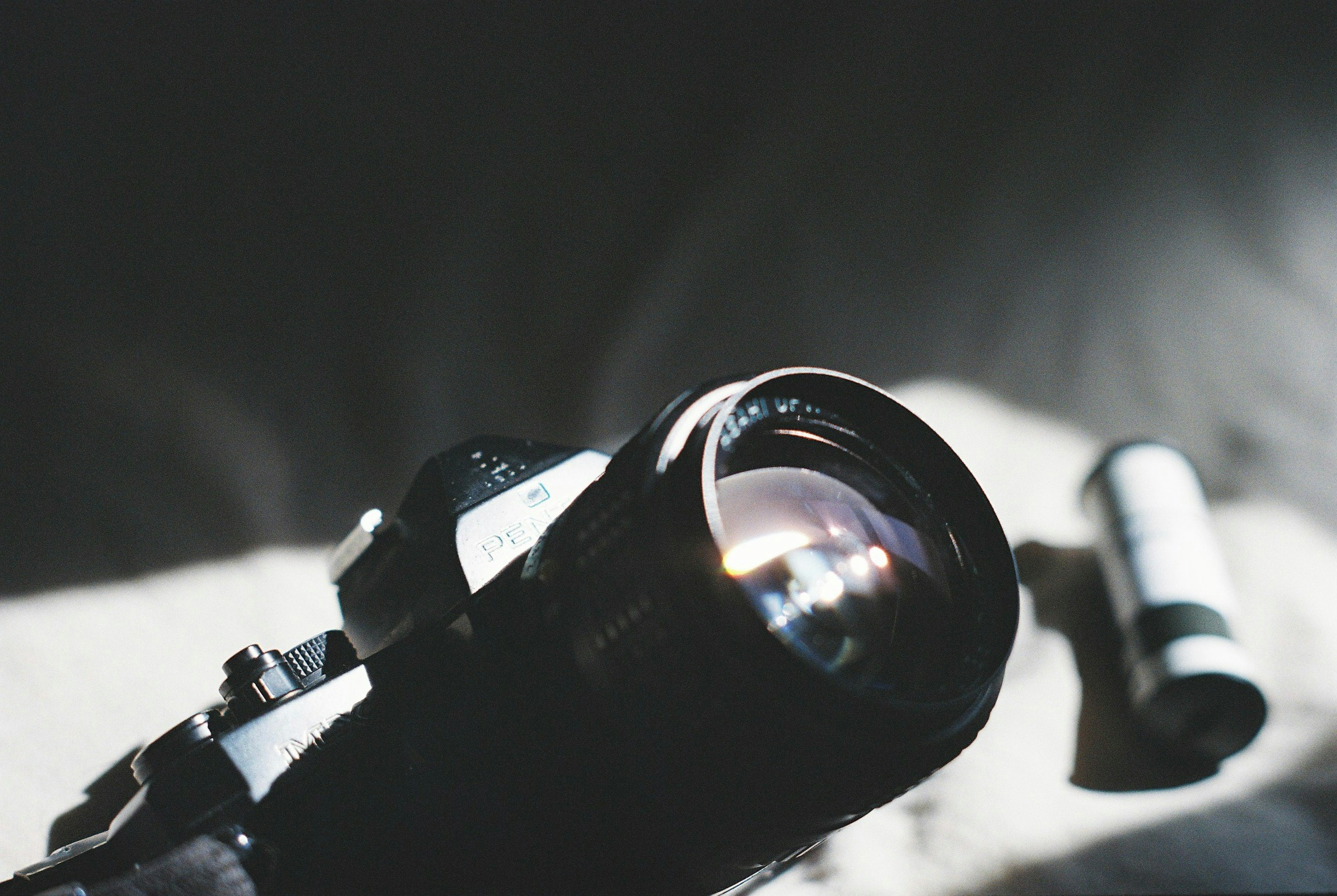 Close-up of a camera lens with soft lighting and shadows