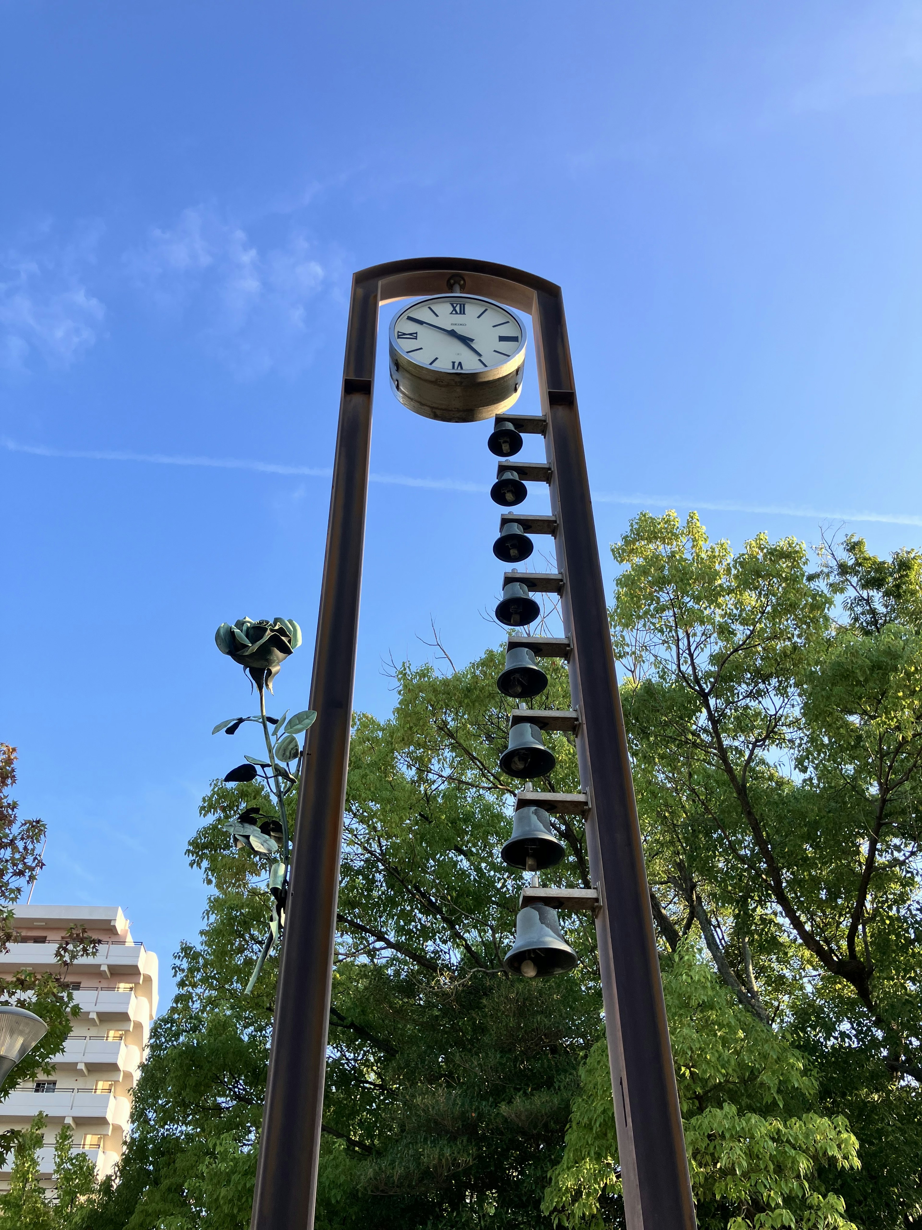 Una scena di parco con una scultura di orologio e campana