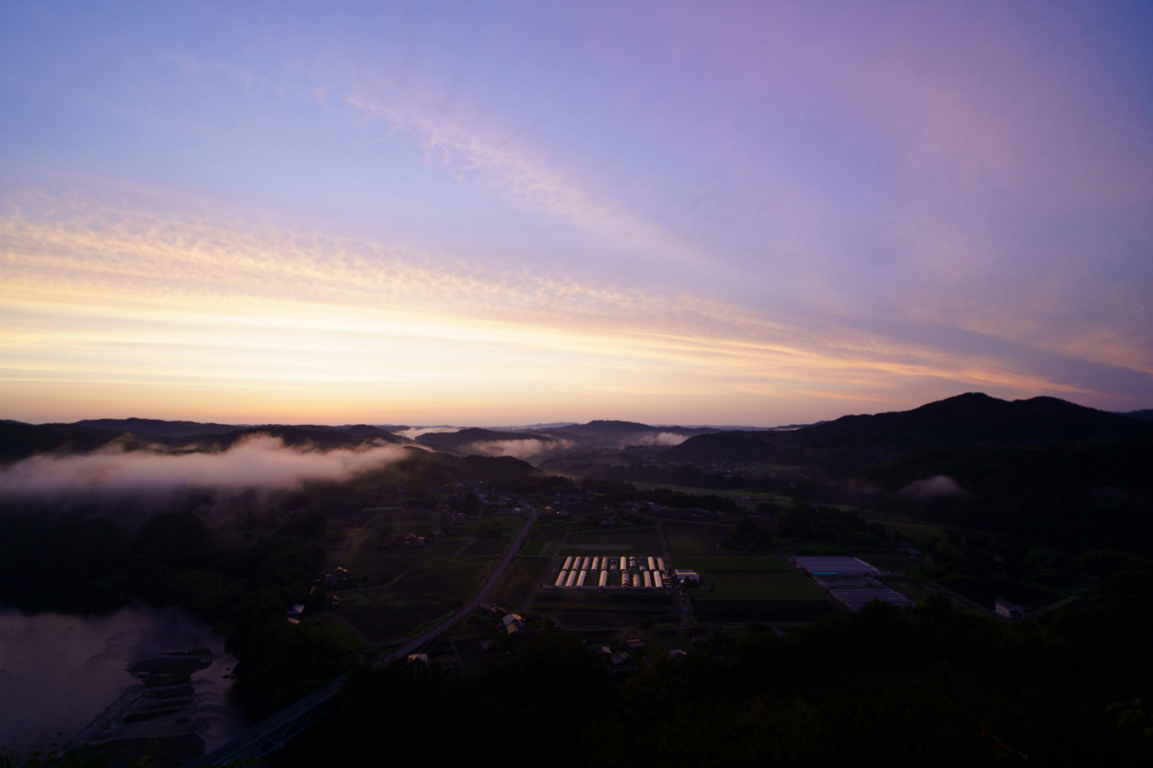 美しい夕焼けの風景と霧に包まれた山々