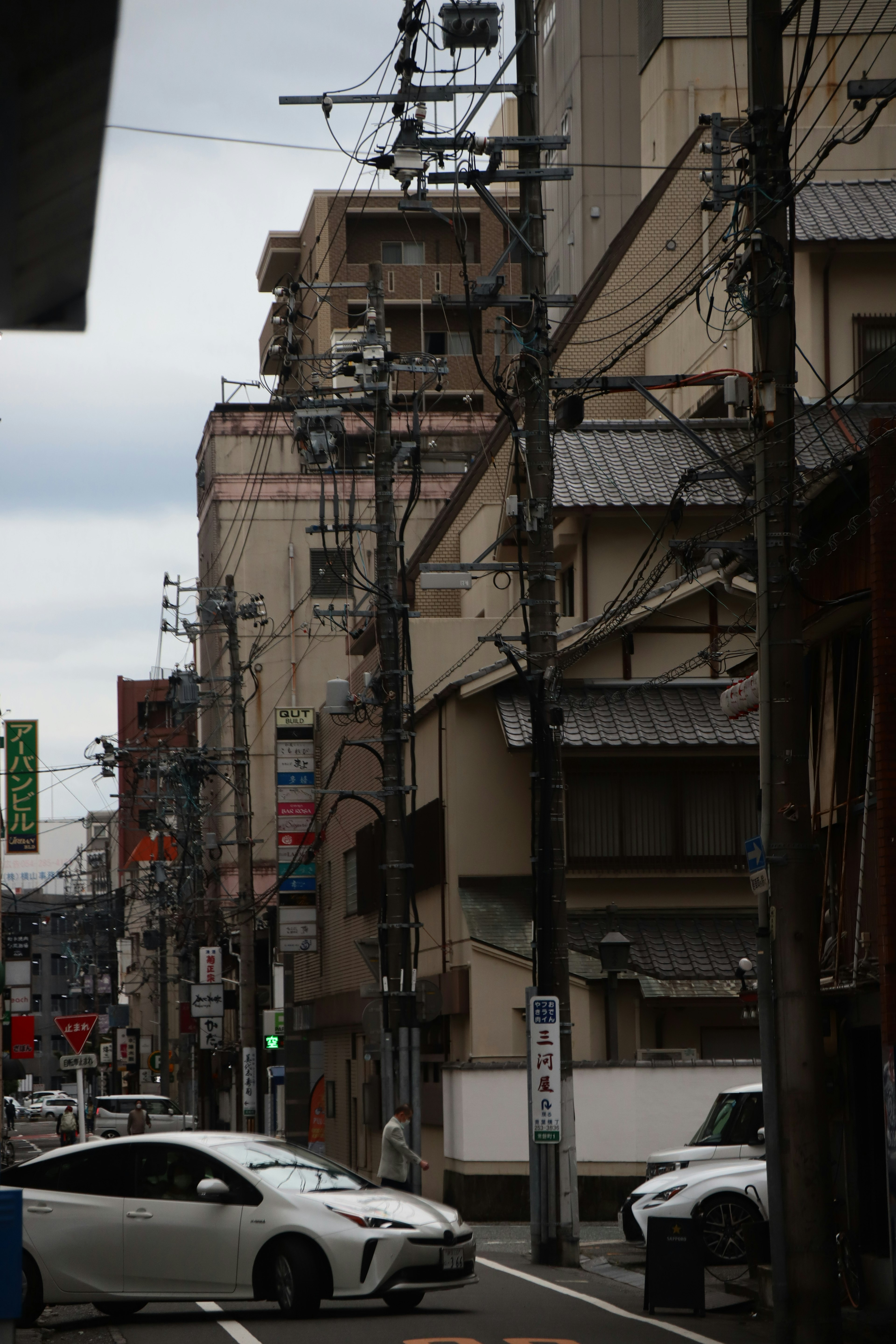 Urban street scene in Japan featuring old buildings and utility poles