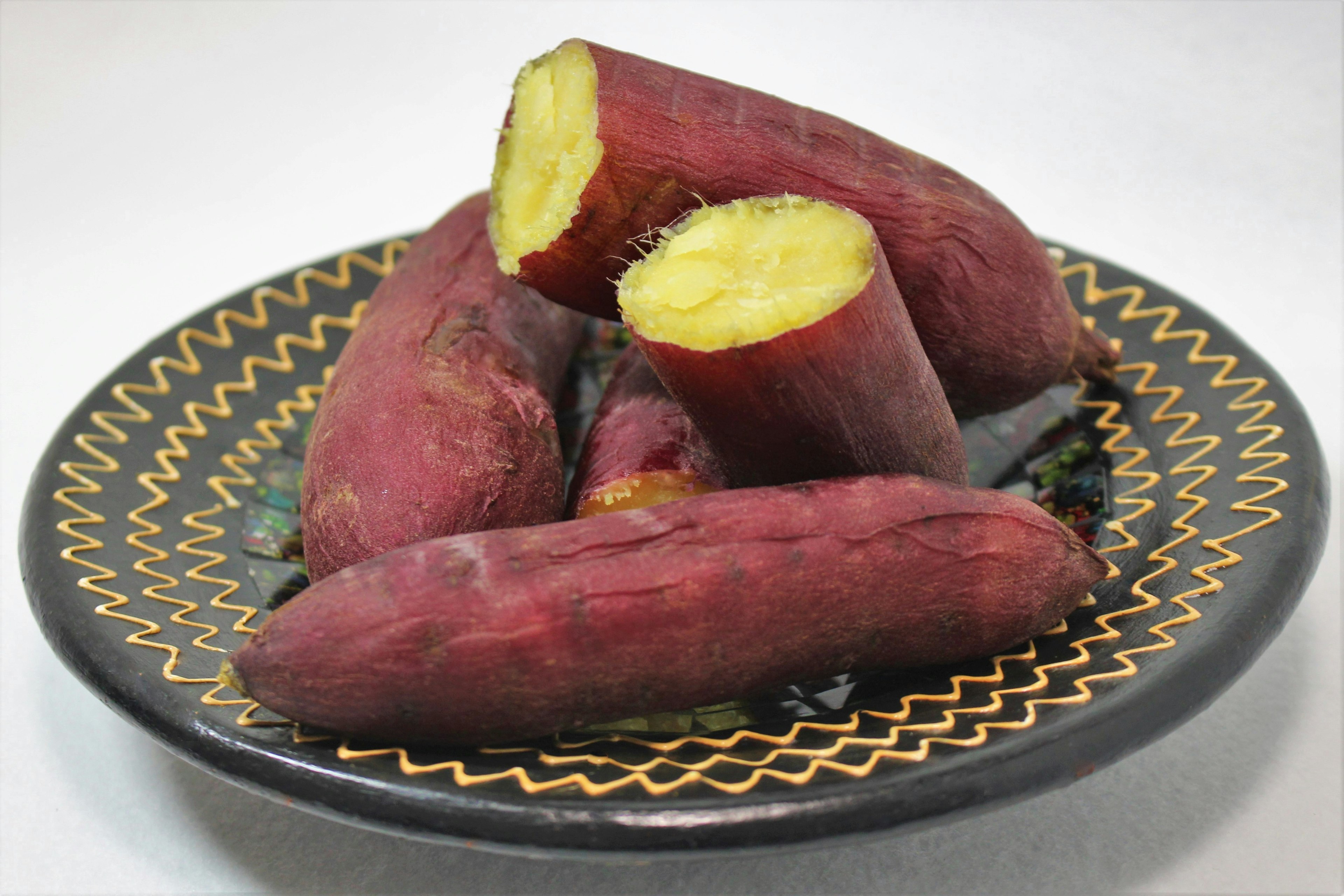 Sweet potatoes arranged on a black plate