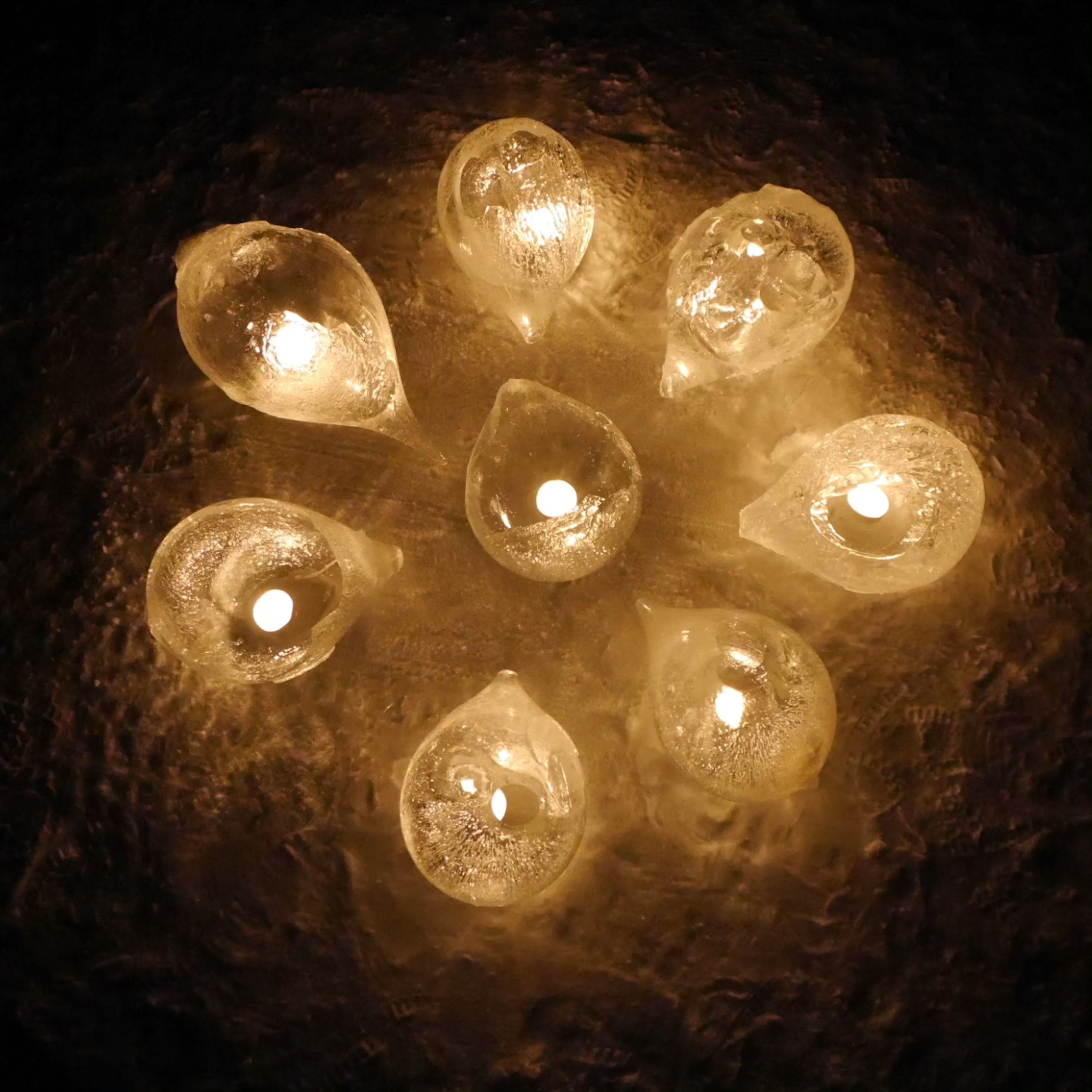 Une belle exposition de bougies en forme de goutte disposées en cercle émettant une lumière chaude