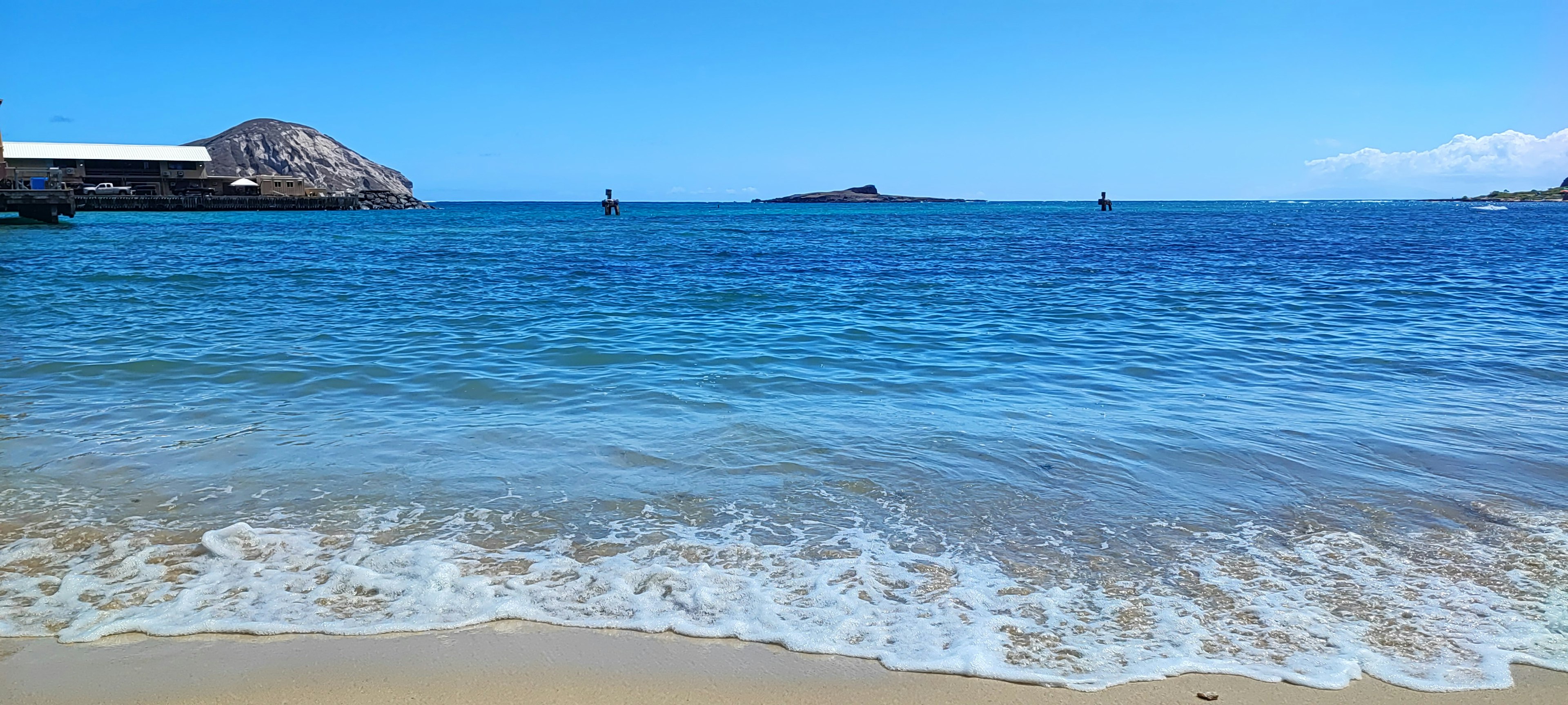 Una vista panoramica di una spiaggia con acqua blu chiaro e sabbia bianca