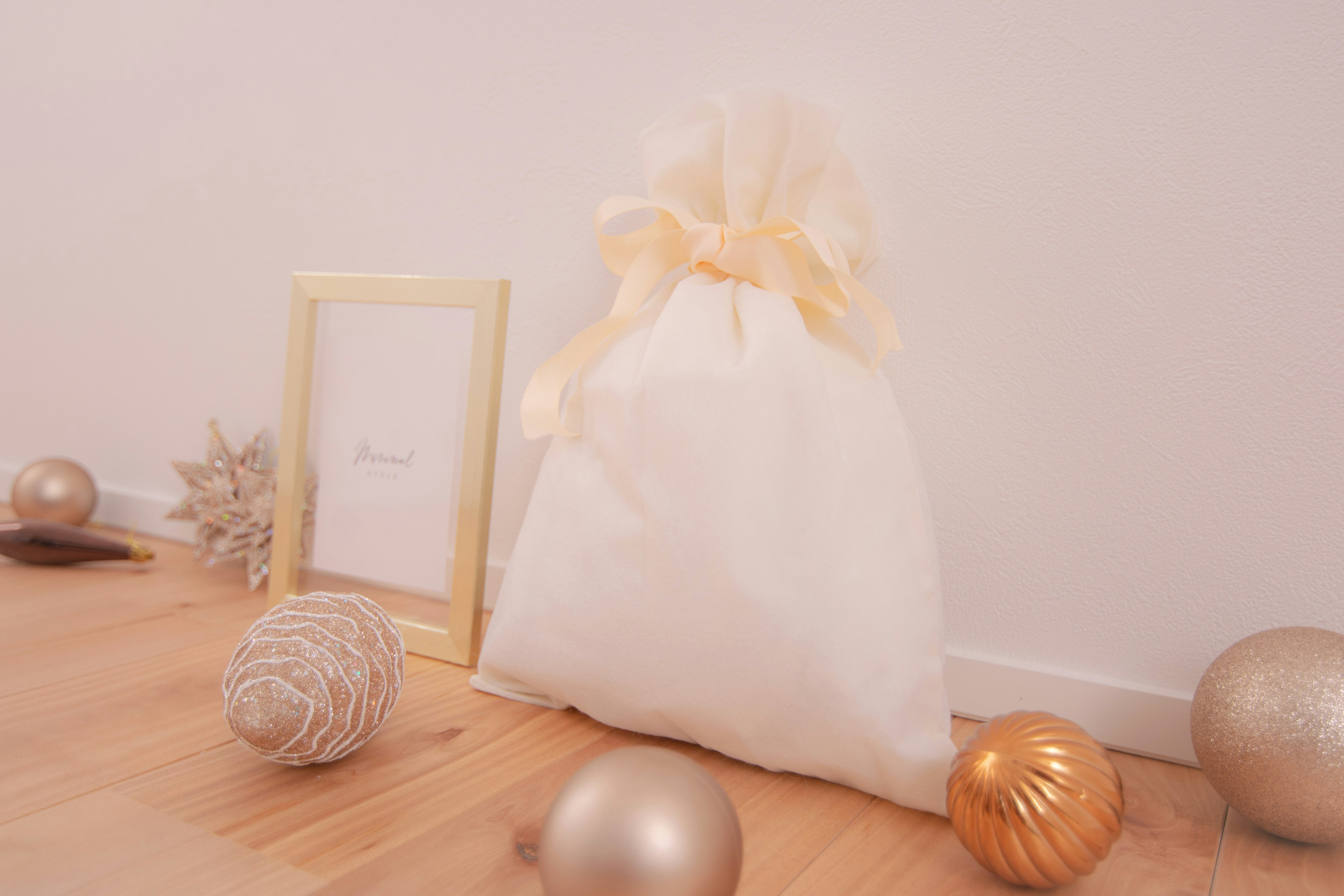 White fabric bag with golden ornaments scattered around in a warm indoor setting