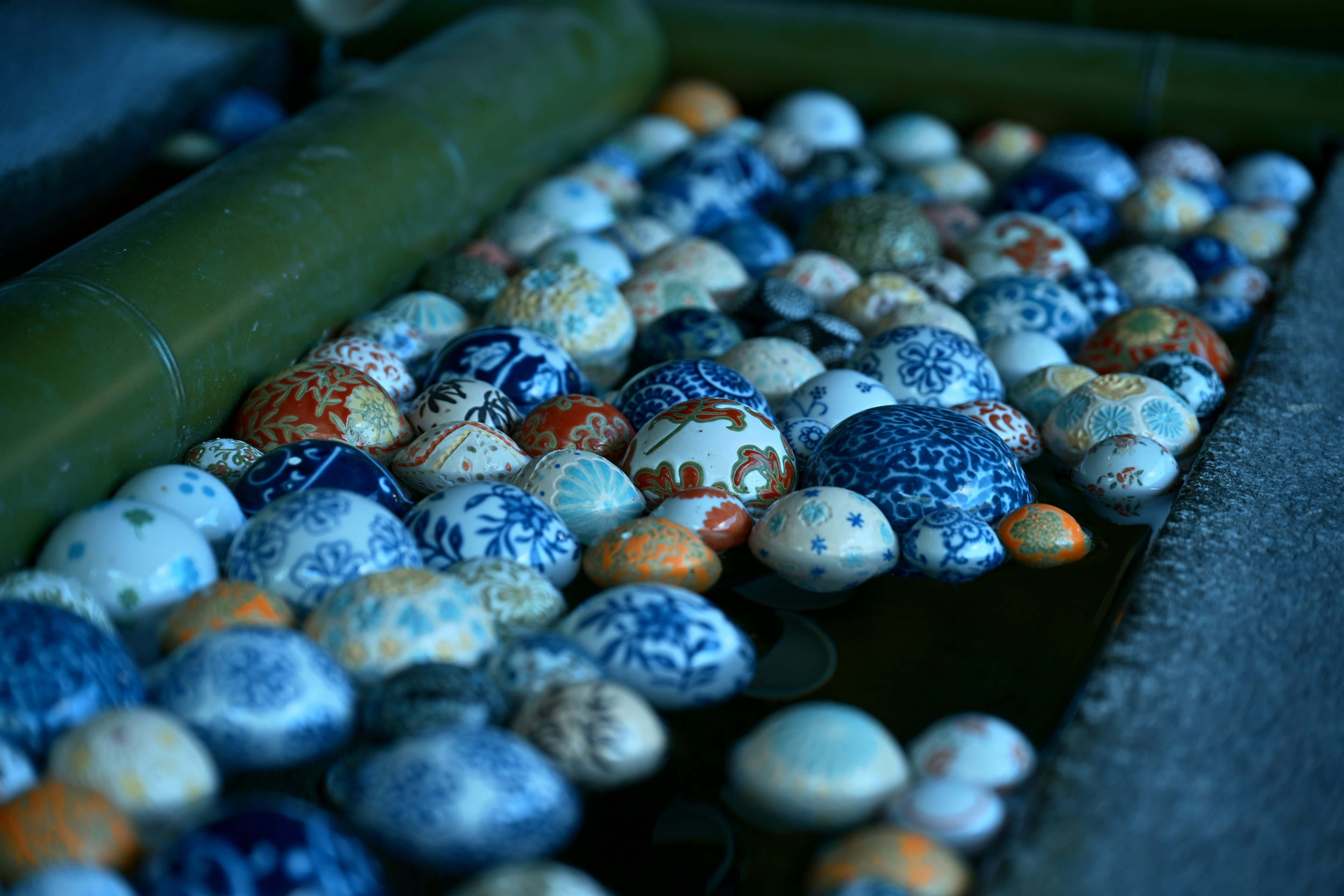 Colorful patterned eggs floating on water with bamboo