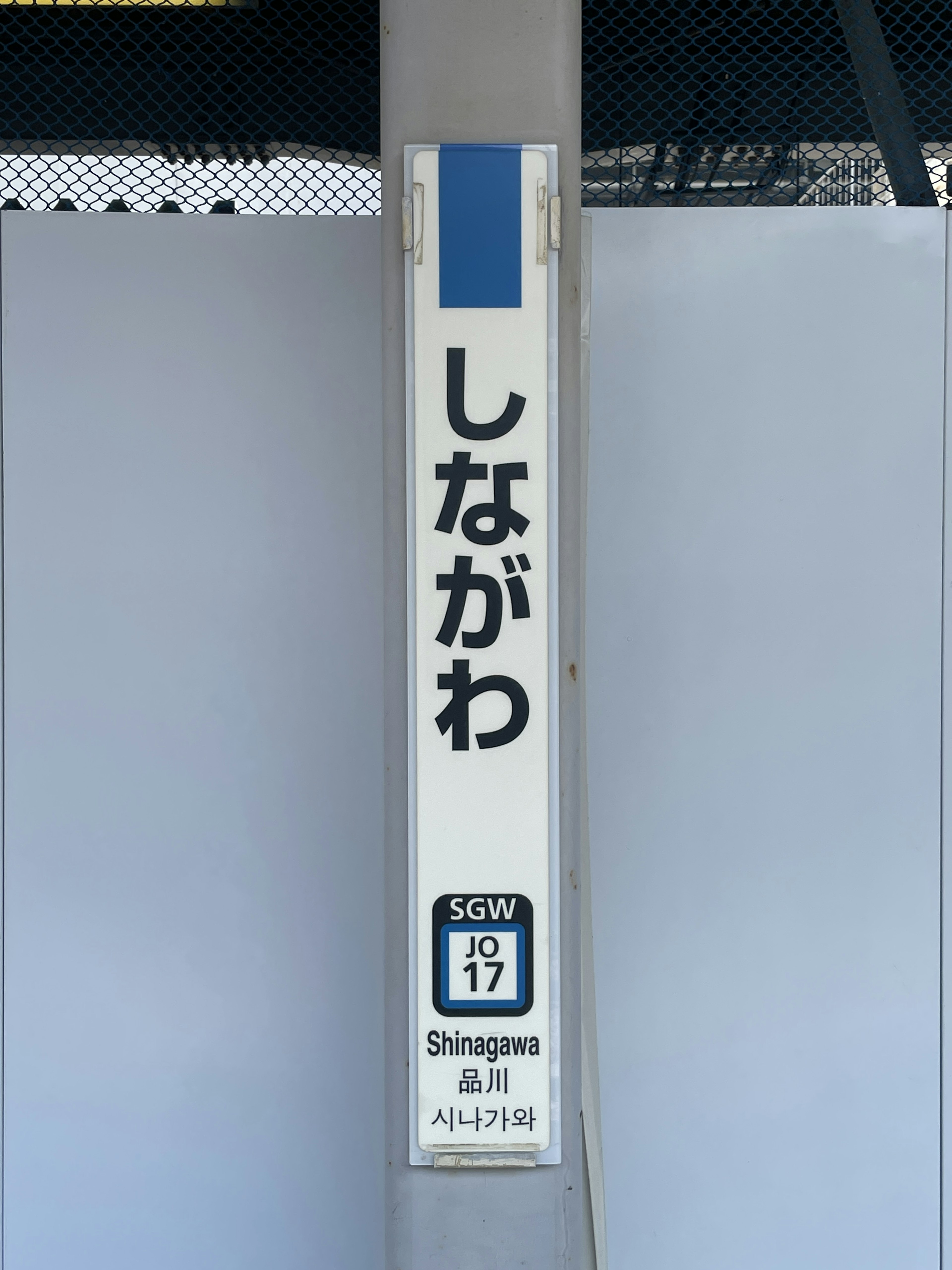 Signage for Shinagawa Station featuring blue border and white background