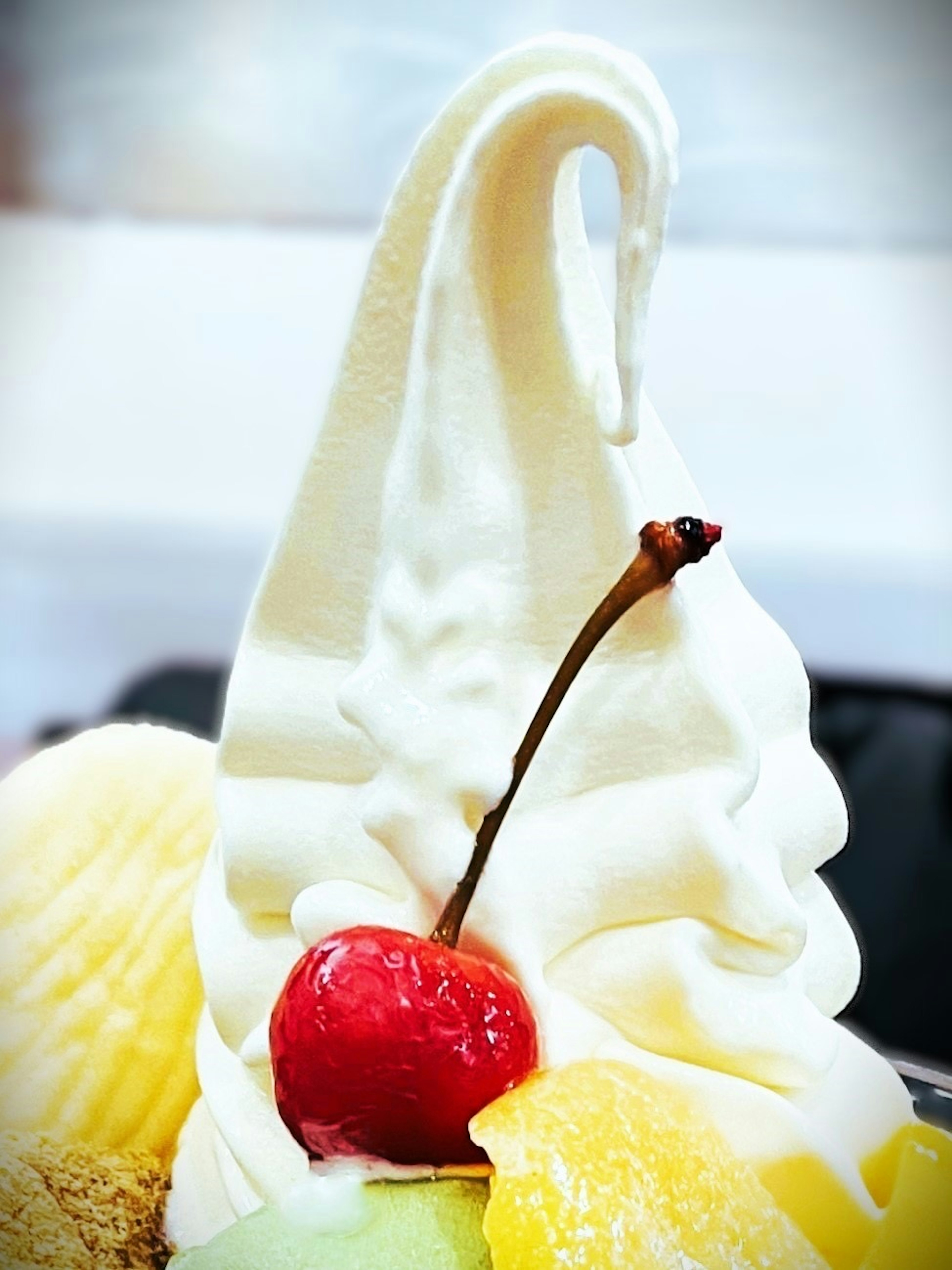 Soft serve ice cream topped with a red cherry