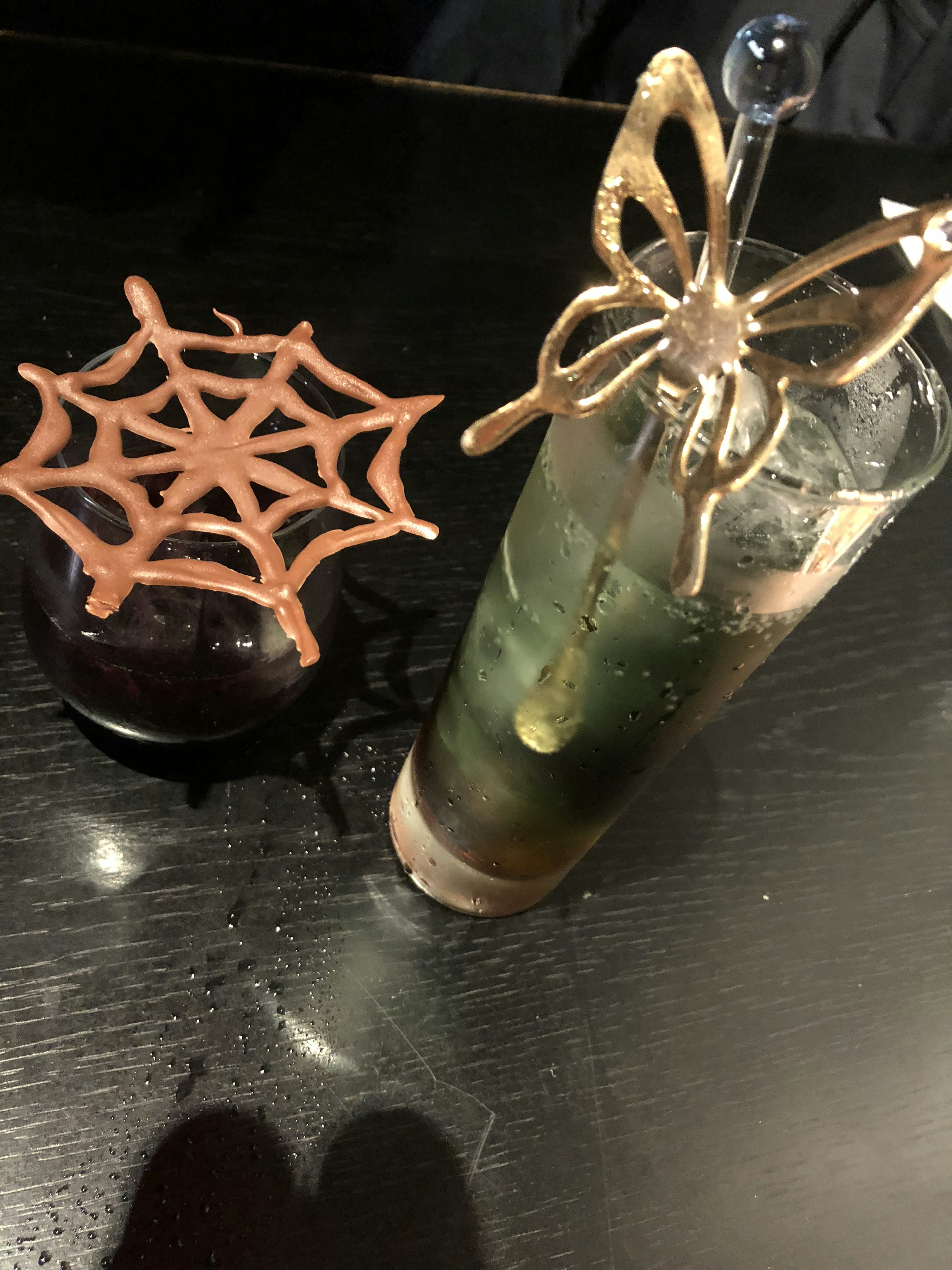 Una bebida con decoración de araña y un postre de telaraña