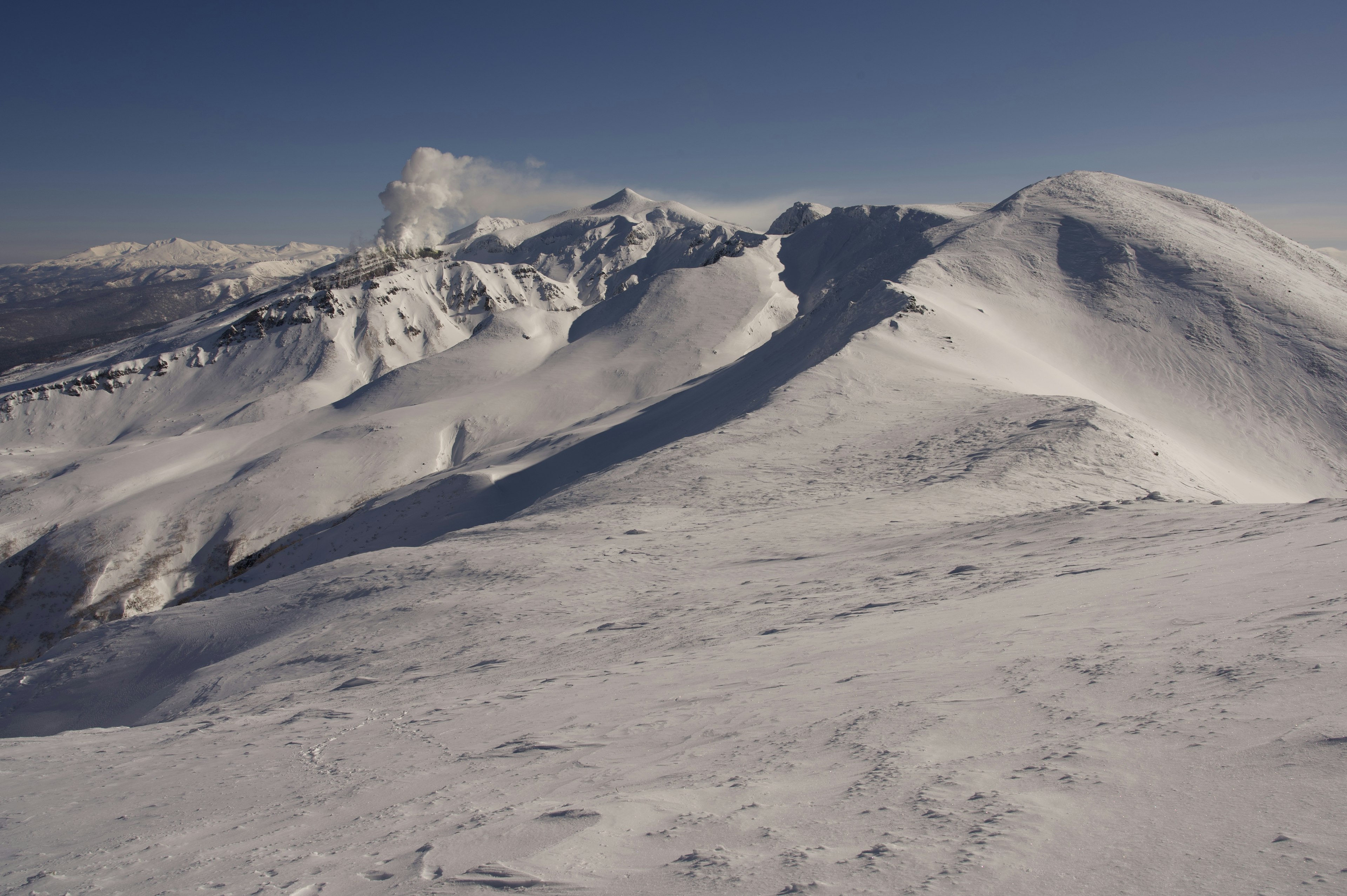 Snow-covered mountains under a clear blue sky