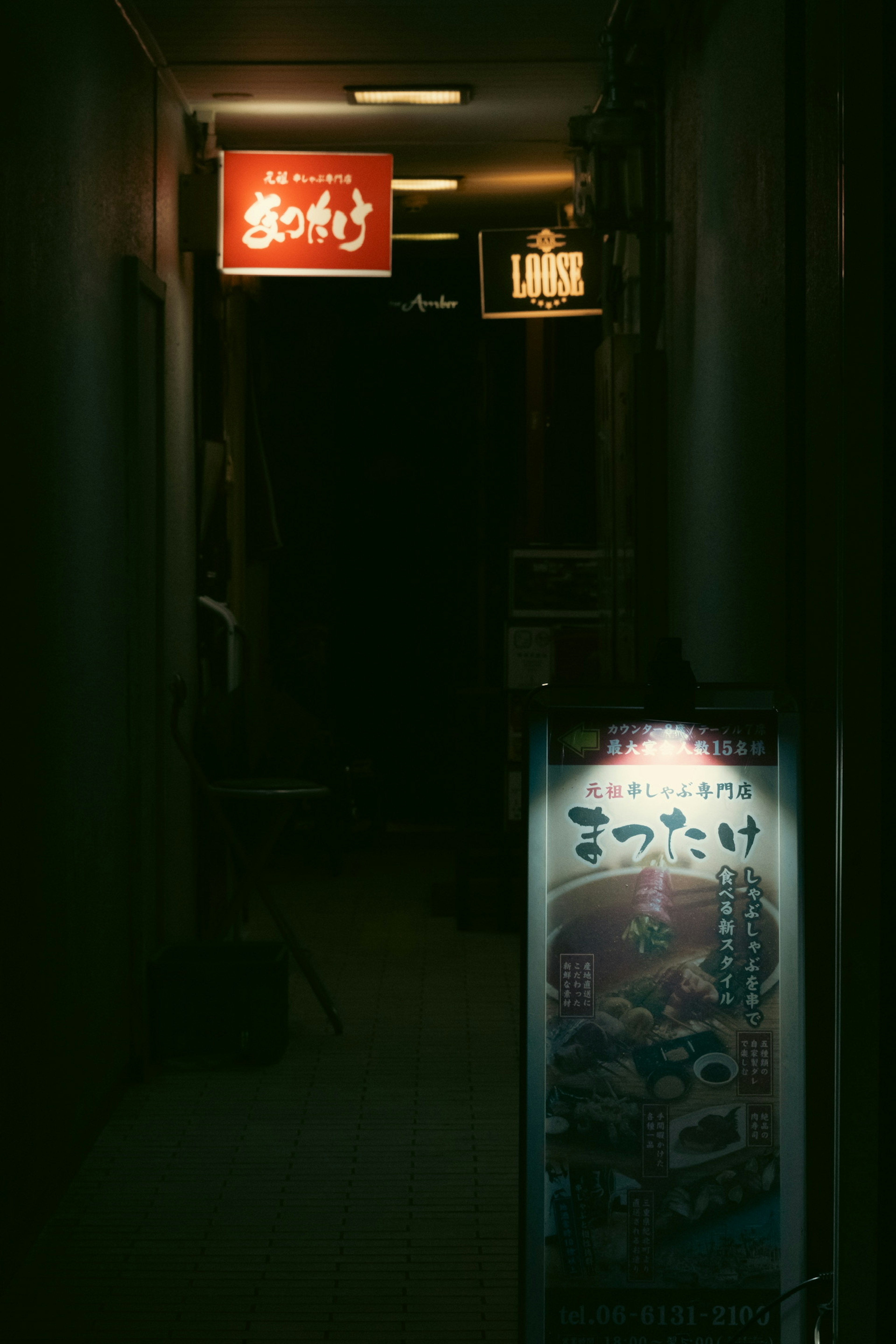 Couloir sombre avec un panneau rouge et un tableau de menu