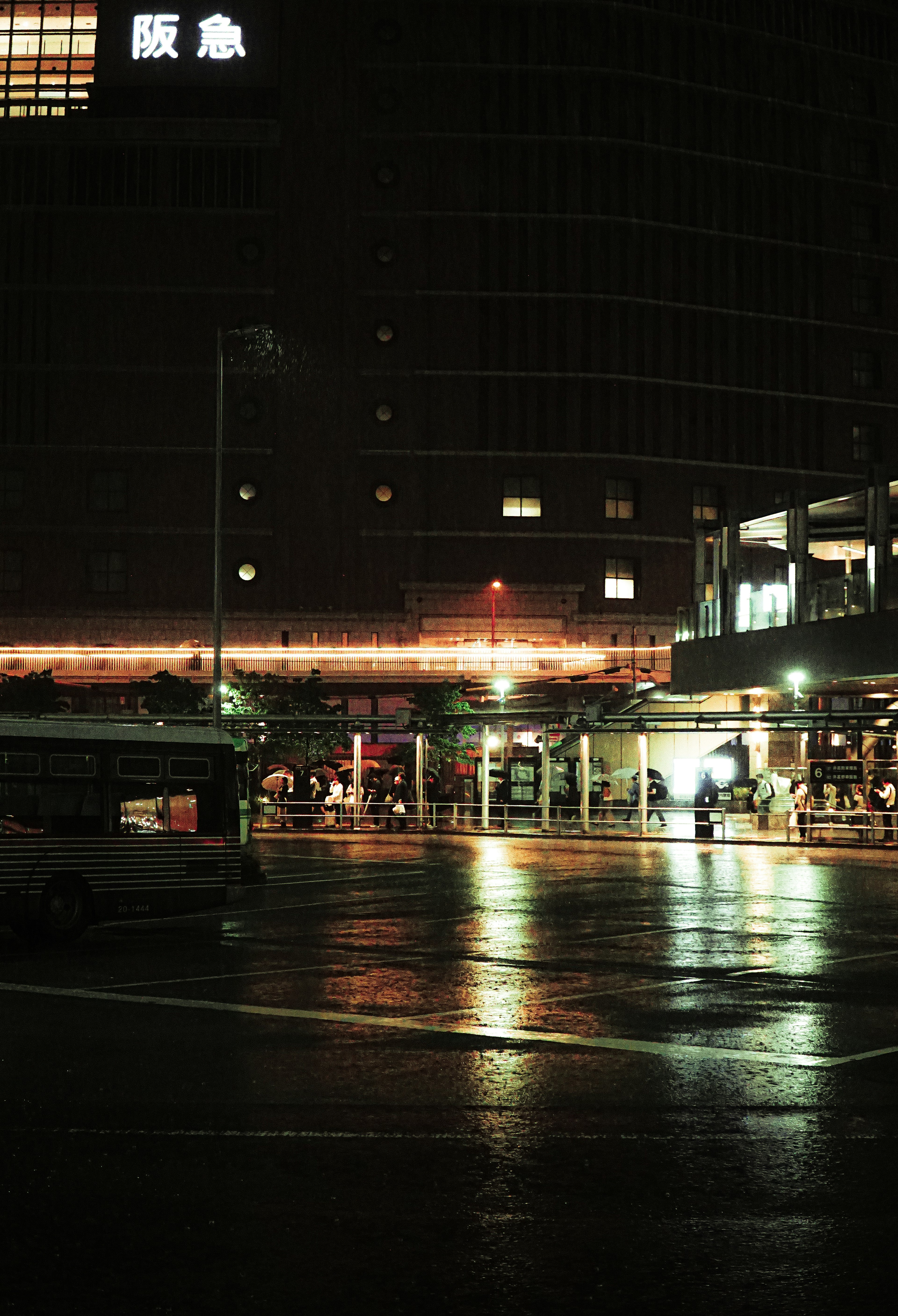 Paisaje urbano nocturno con pavimento mojado reflejando luces de edificios