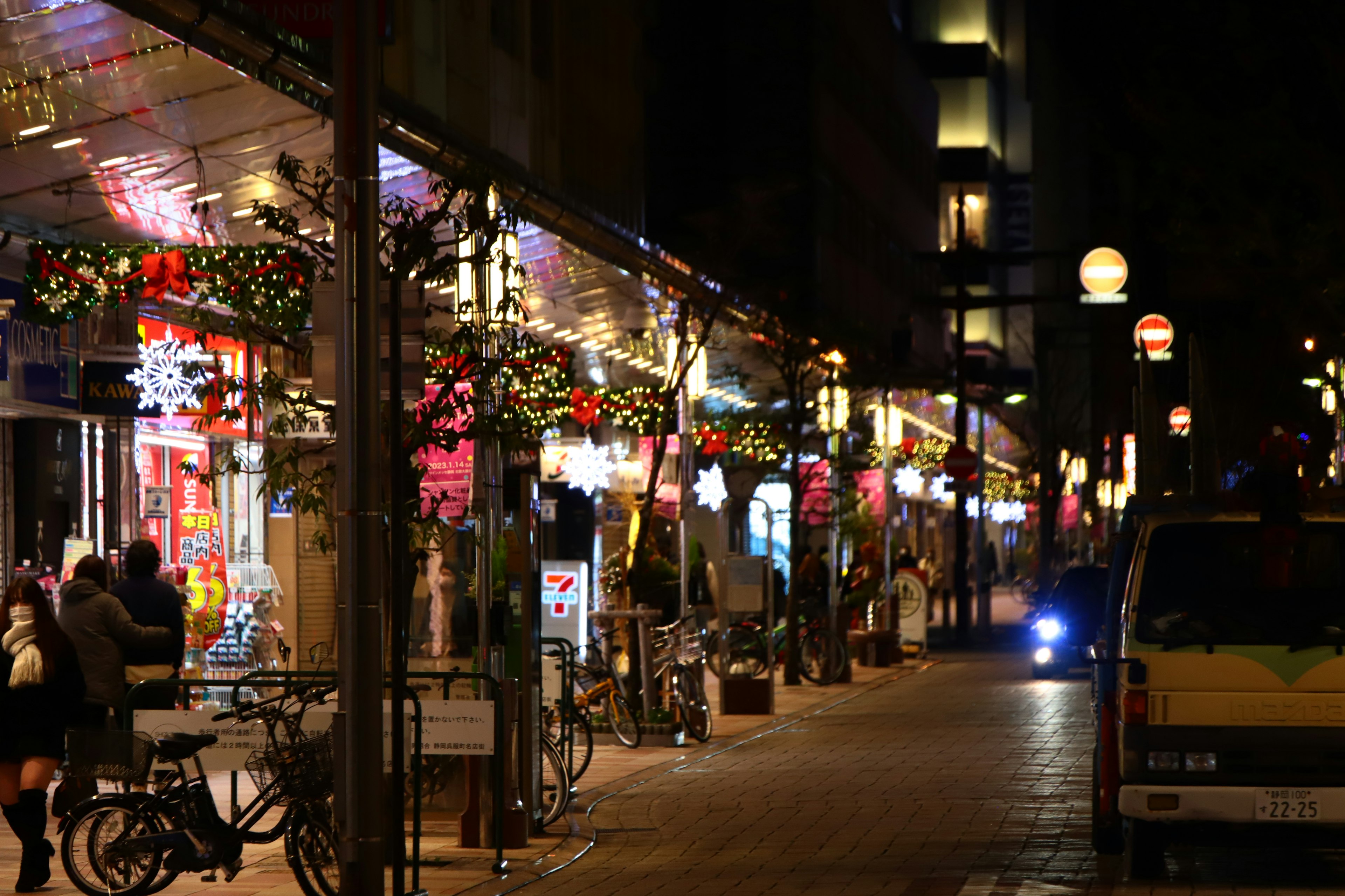 Night street scene with glowing neon lights and decorative displays in a shopping district