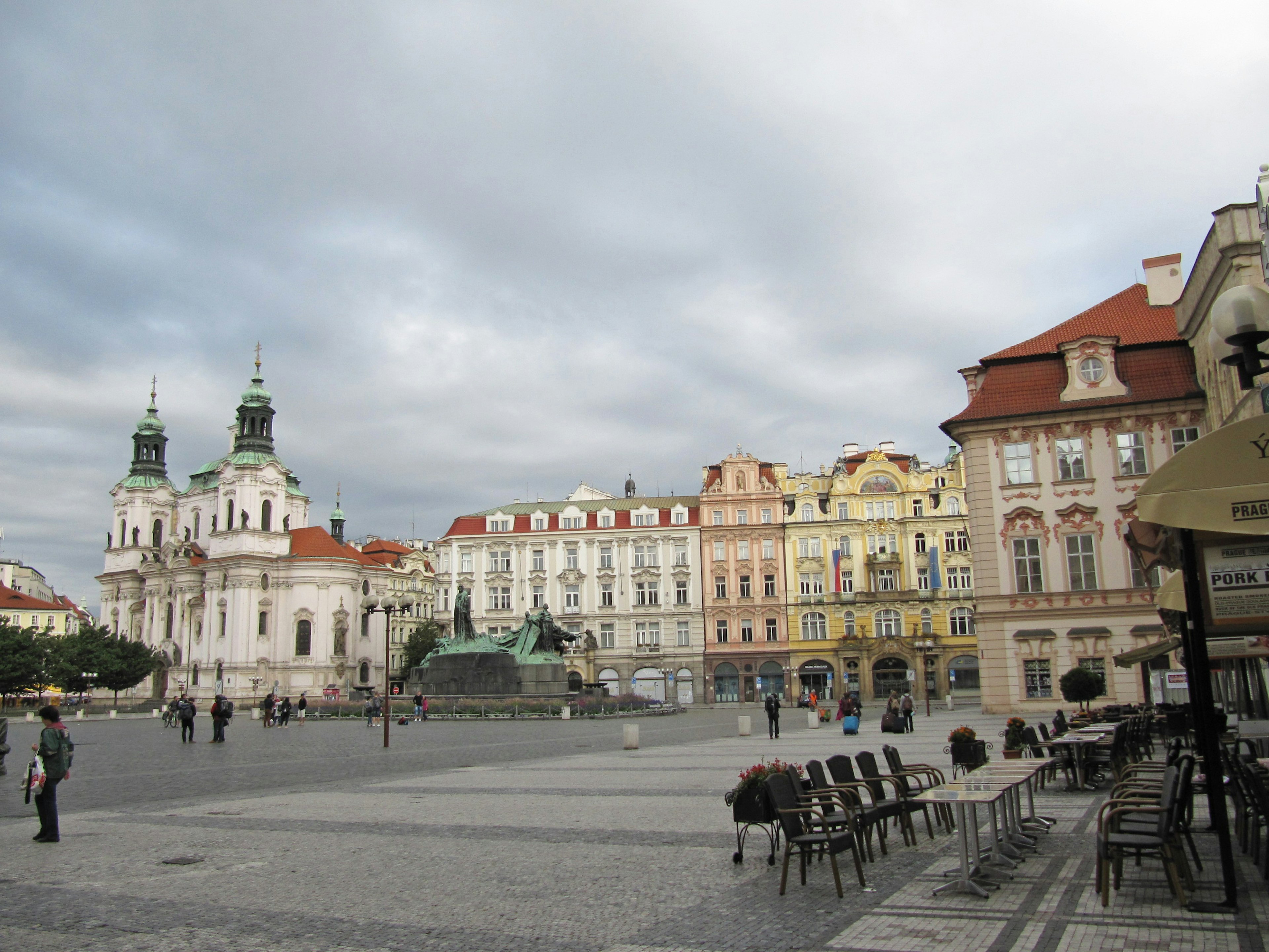 A scenic view of a square with beautiful buildings and a cloudy sky