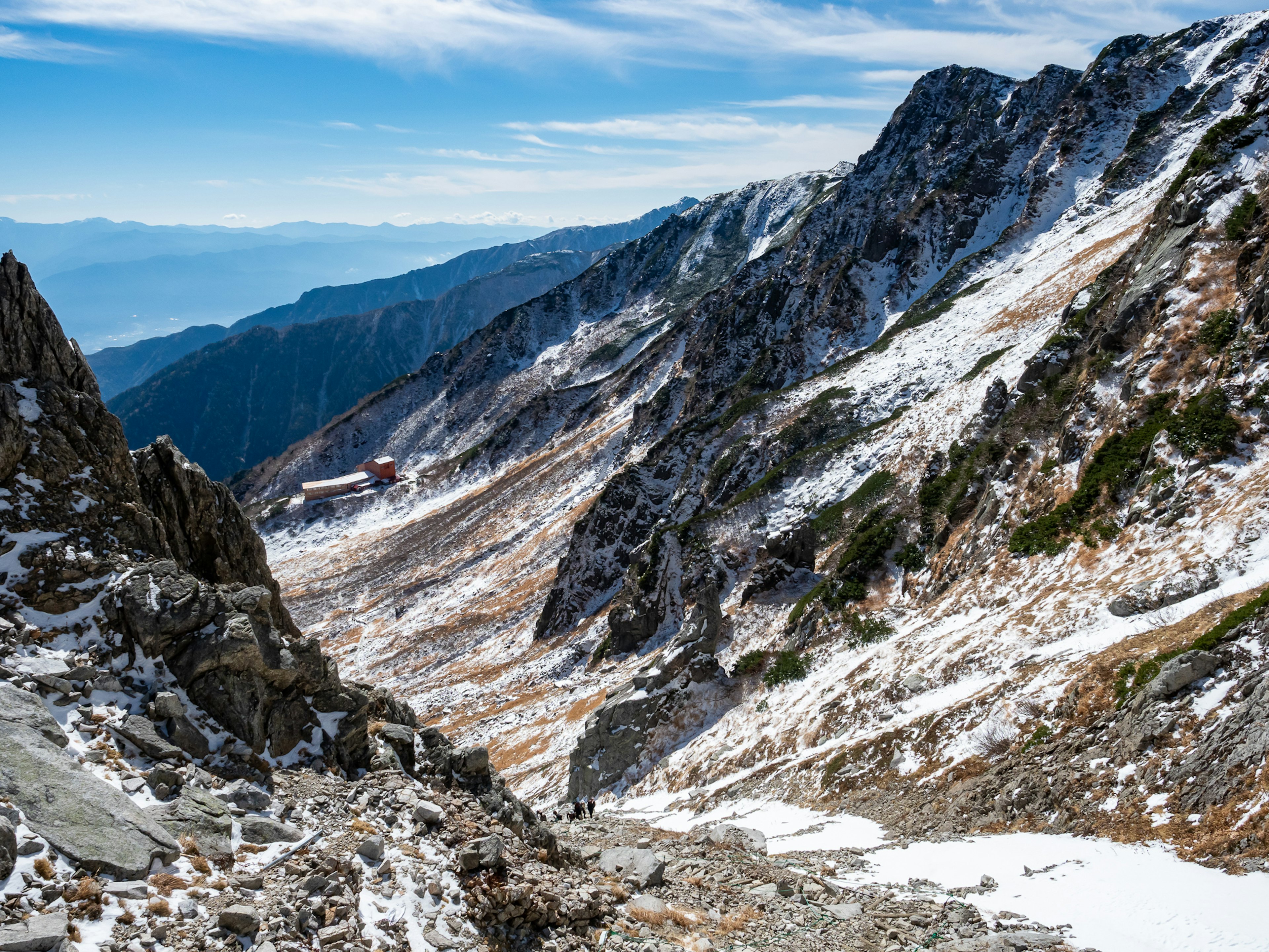 被雪覆盖的山谷与蓝天和岩石地形