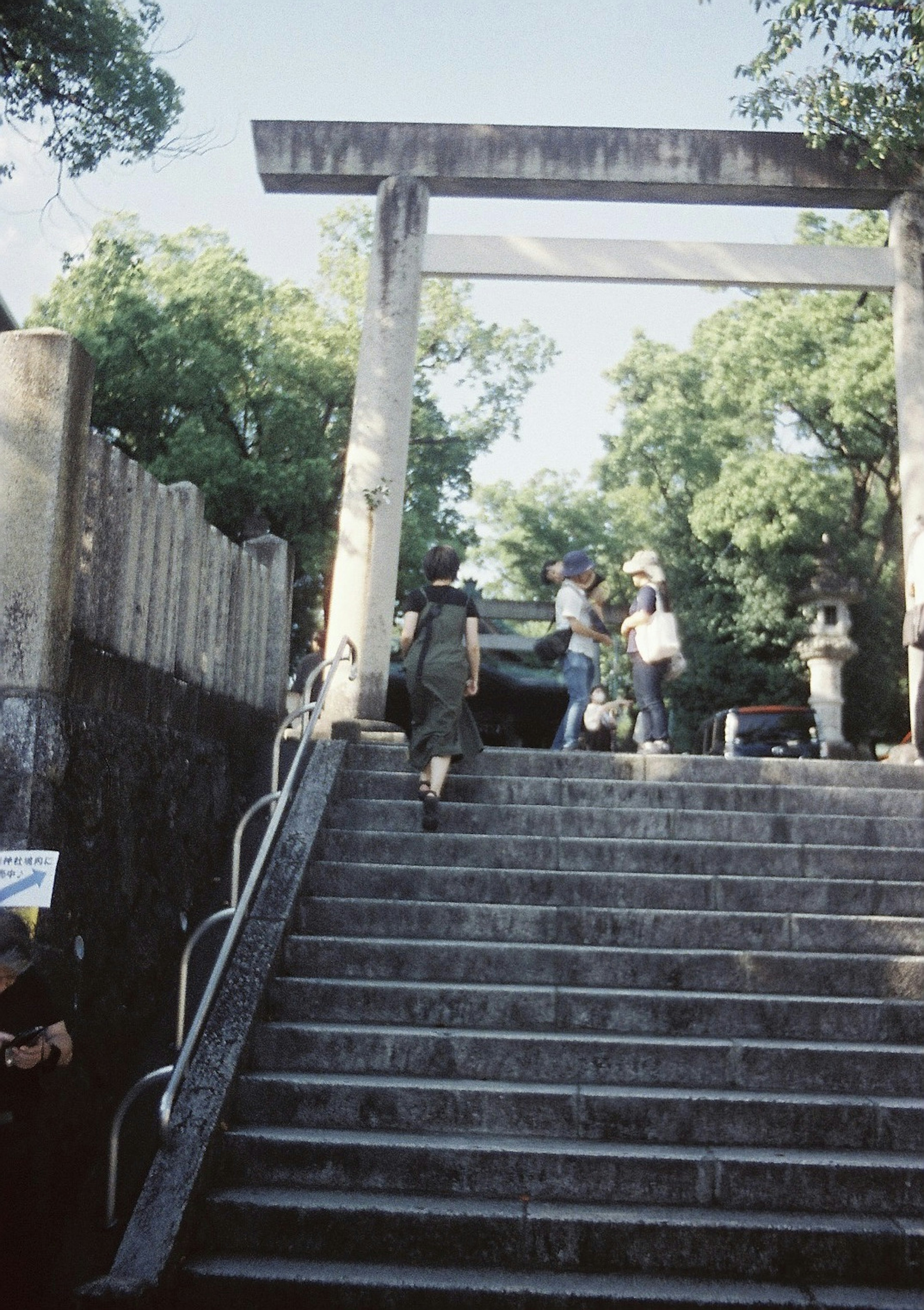 Mọi người đang leo cầu thang với cổng torii ở phía sau