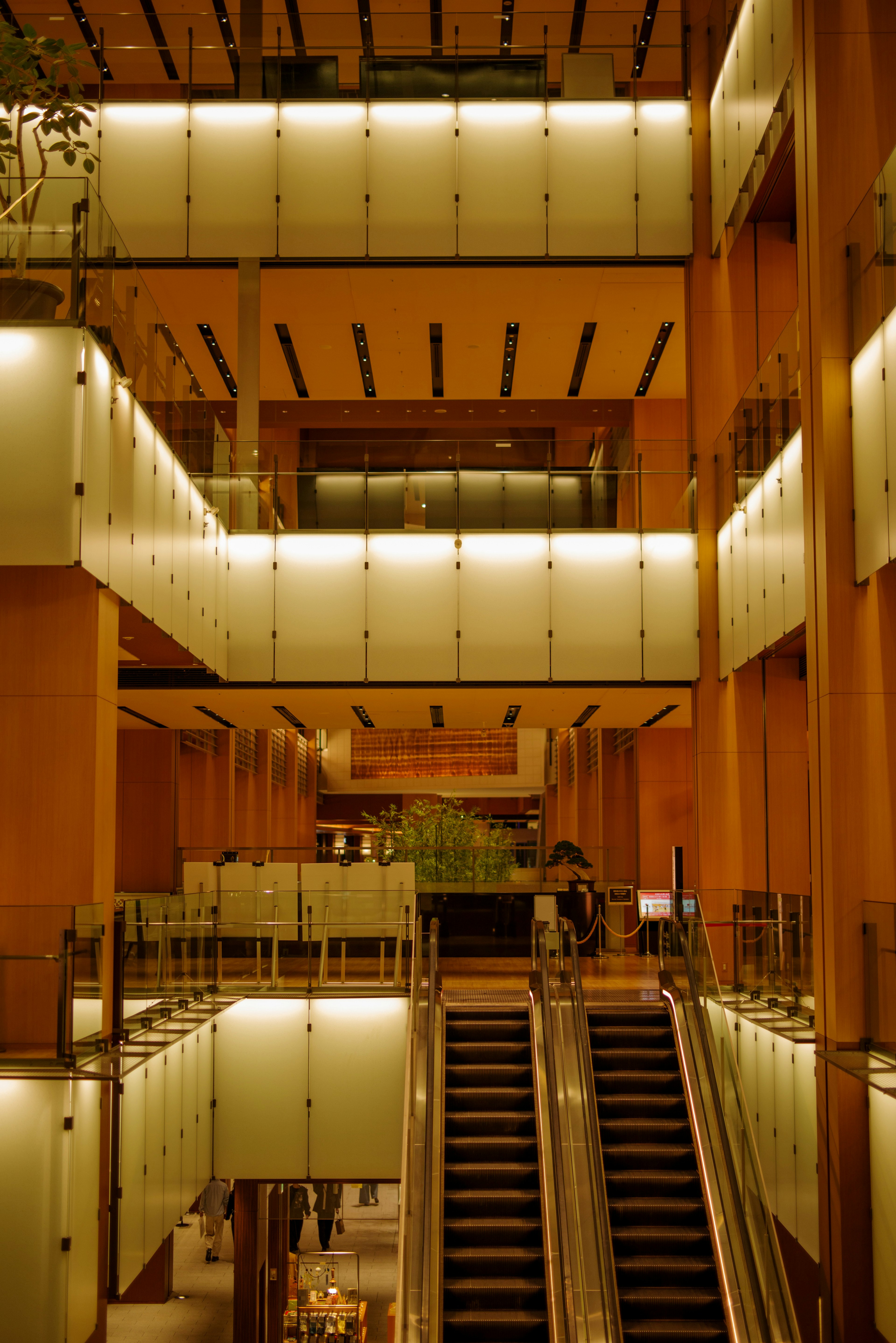 Modern architectural interior featuring glass railings and wooden structures with stairs and multiple floors