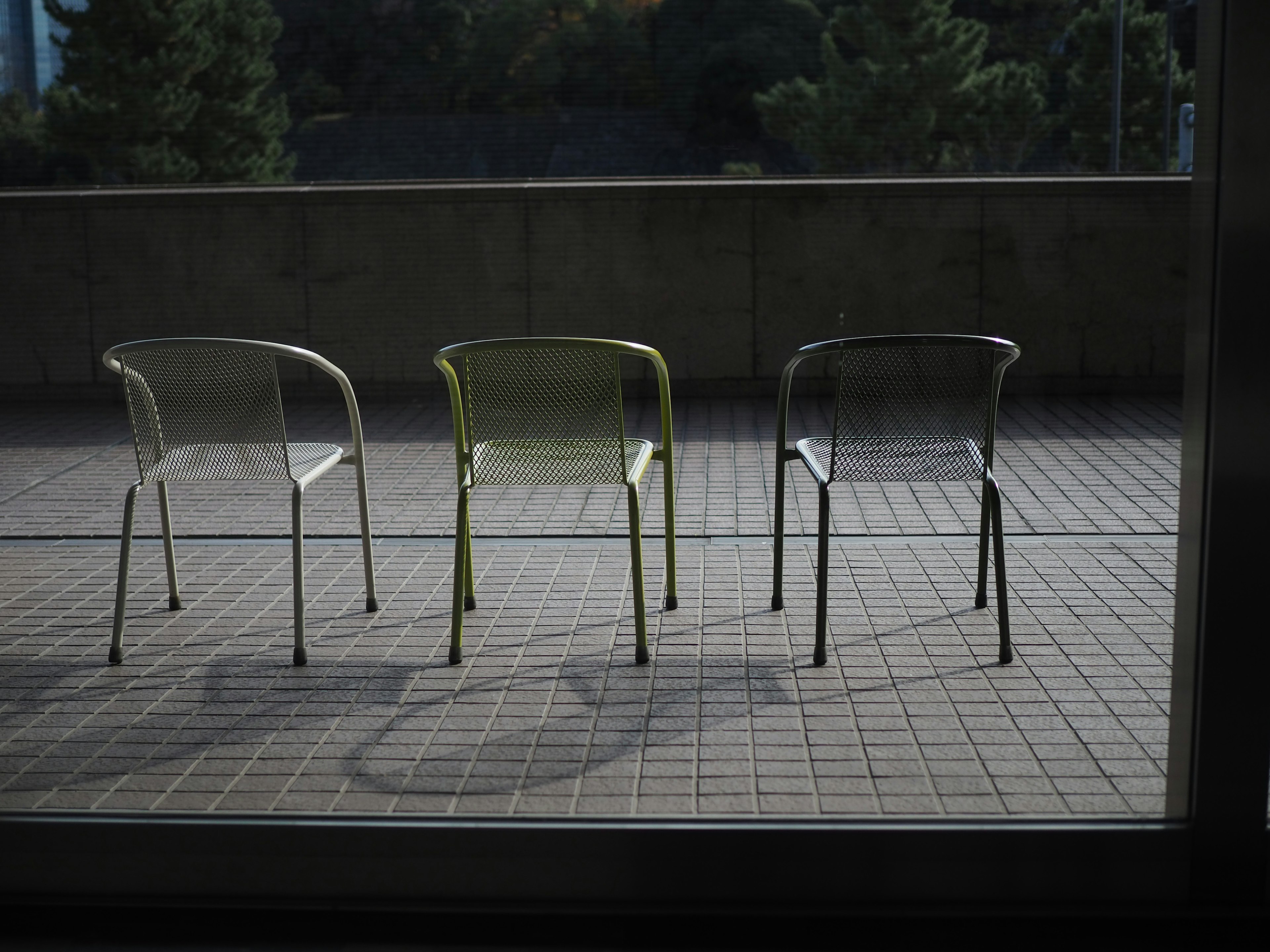 Tre sedie disposte su una terrazza con luce naturale