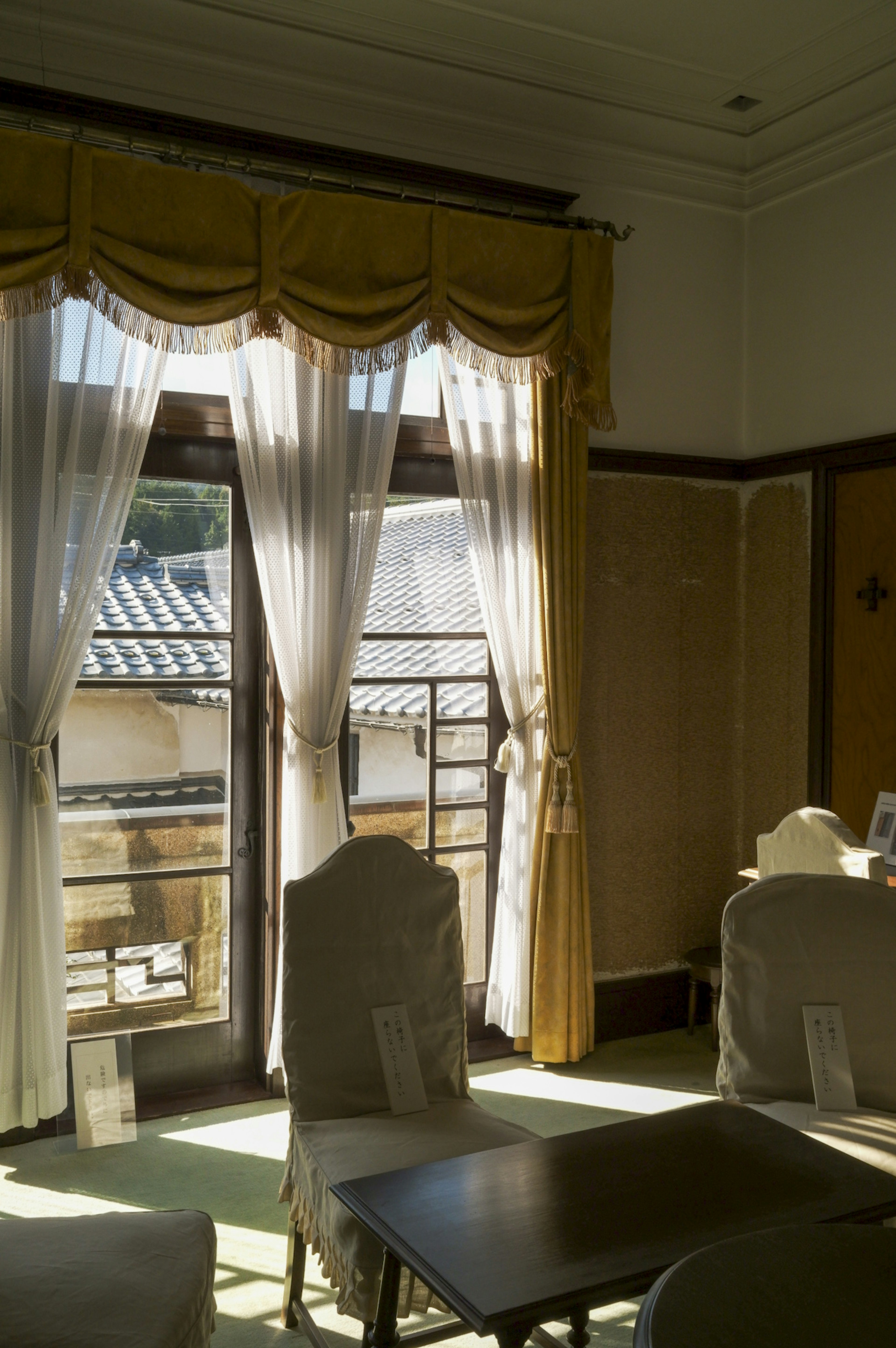 Interior of a room with sunlight streaming through bright curtains