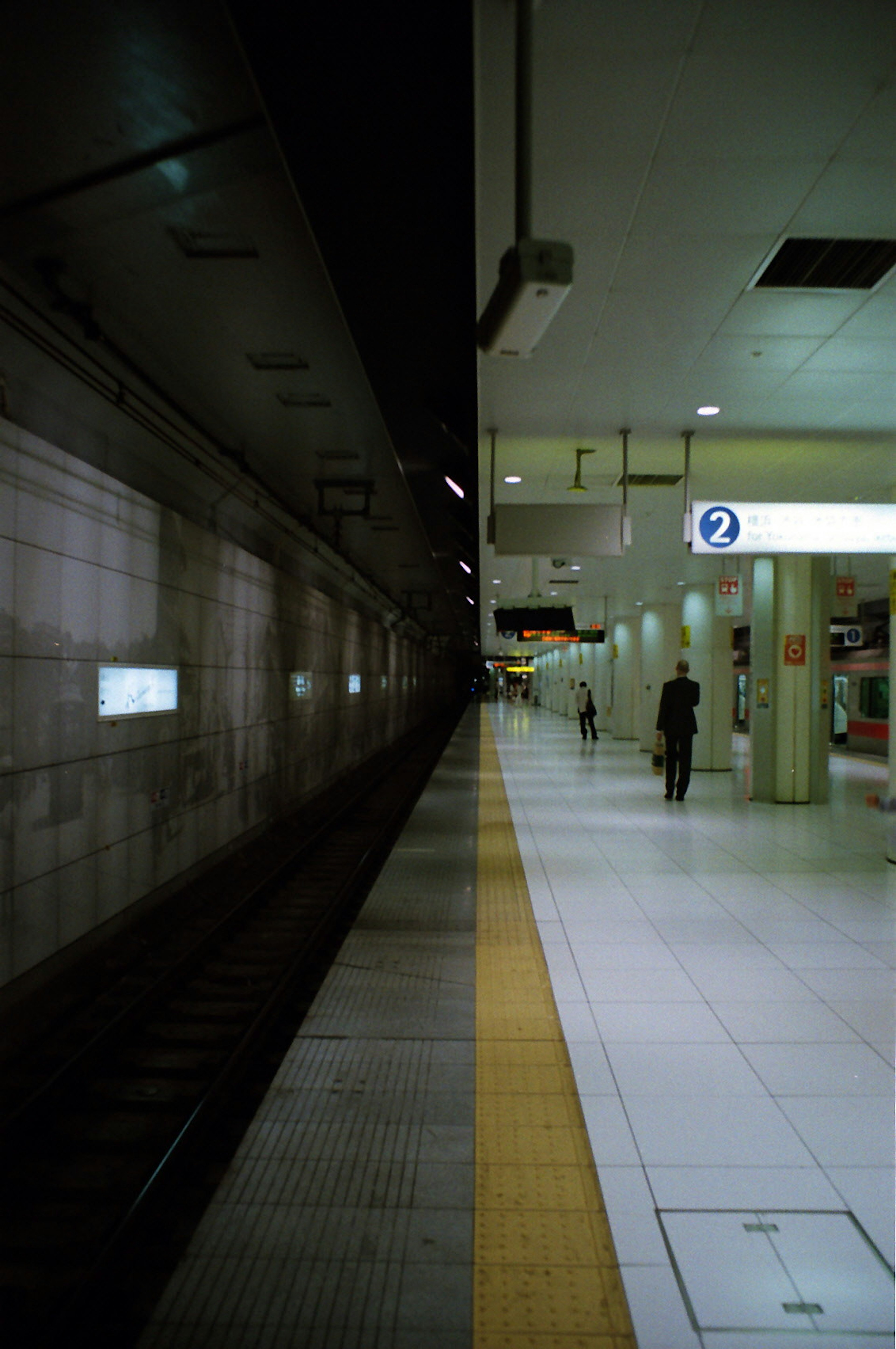 Contraste d'une plateforme de train sombre avec une salle d'attente lumineuse