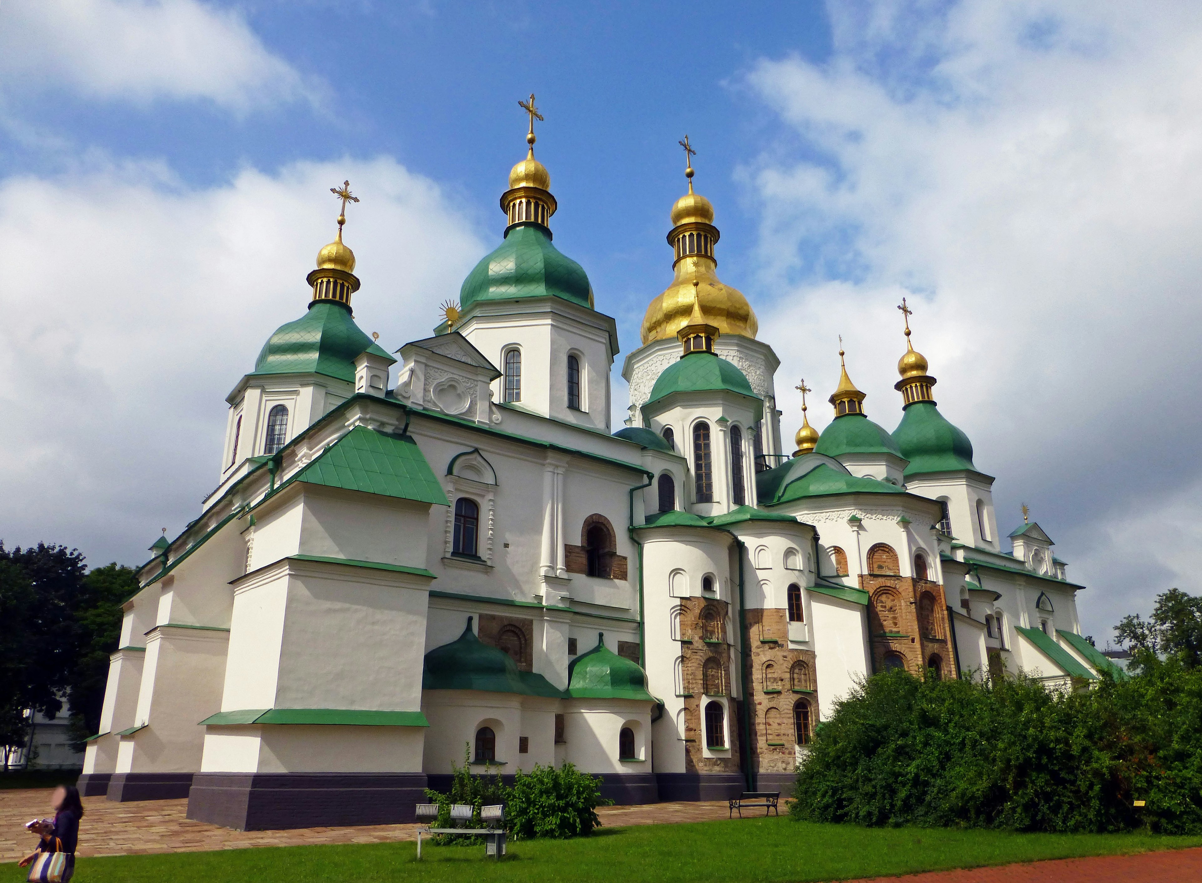 Exterior view of St. Sophia Cathedral featuring green and golden domes