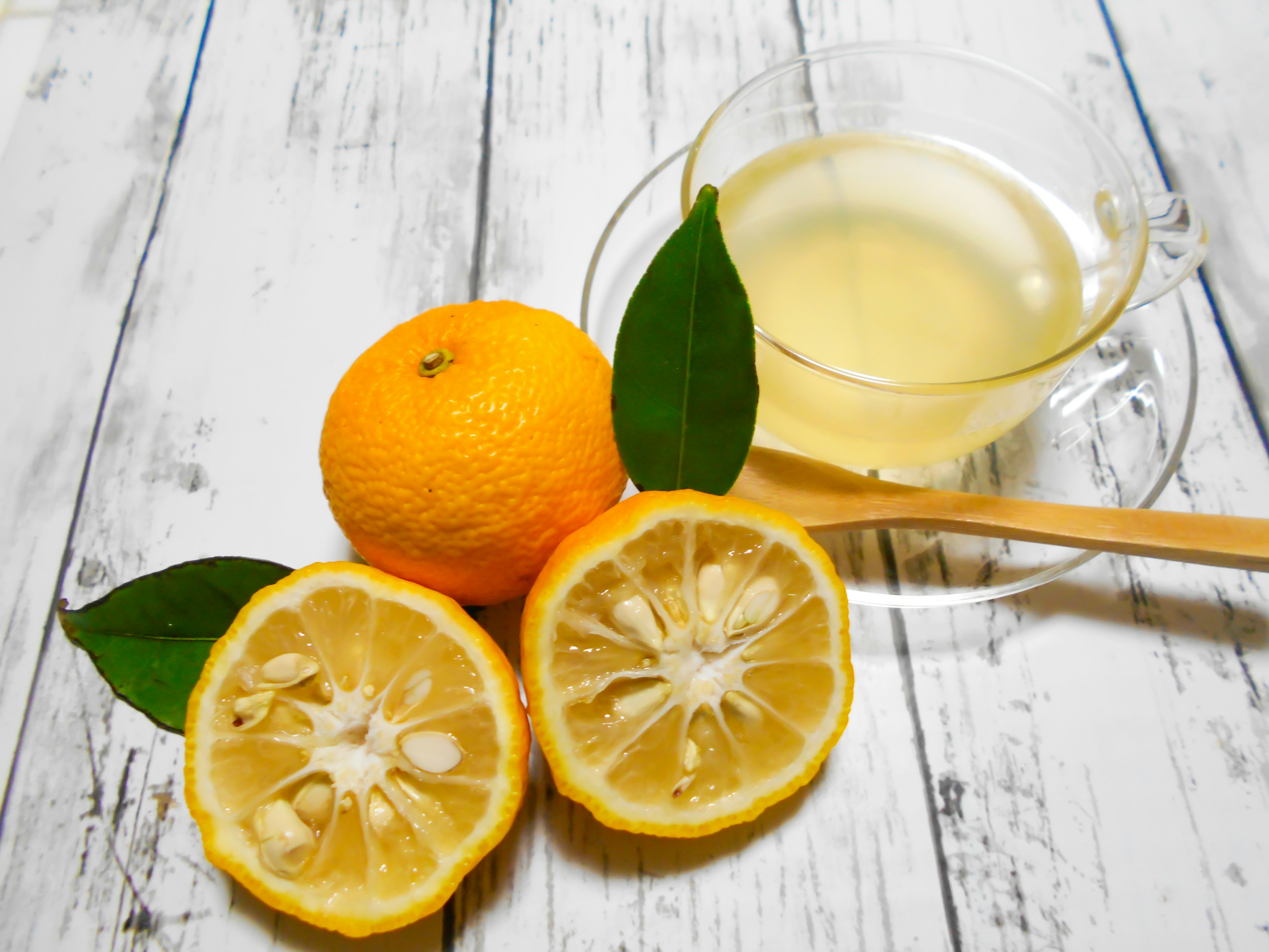 Citron coupé et orange avec une boisson claire sur une table en bois