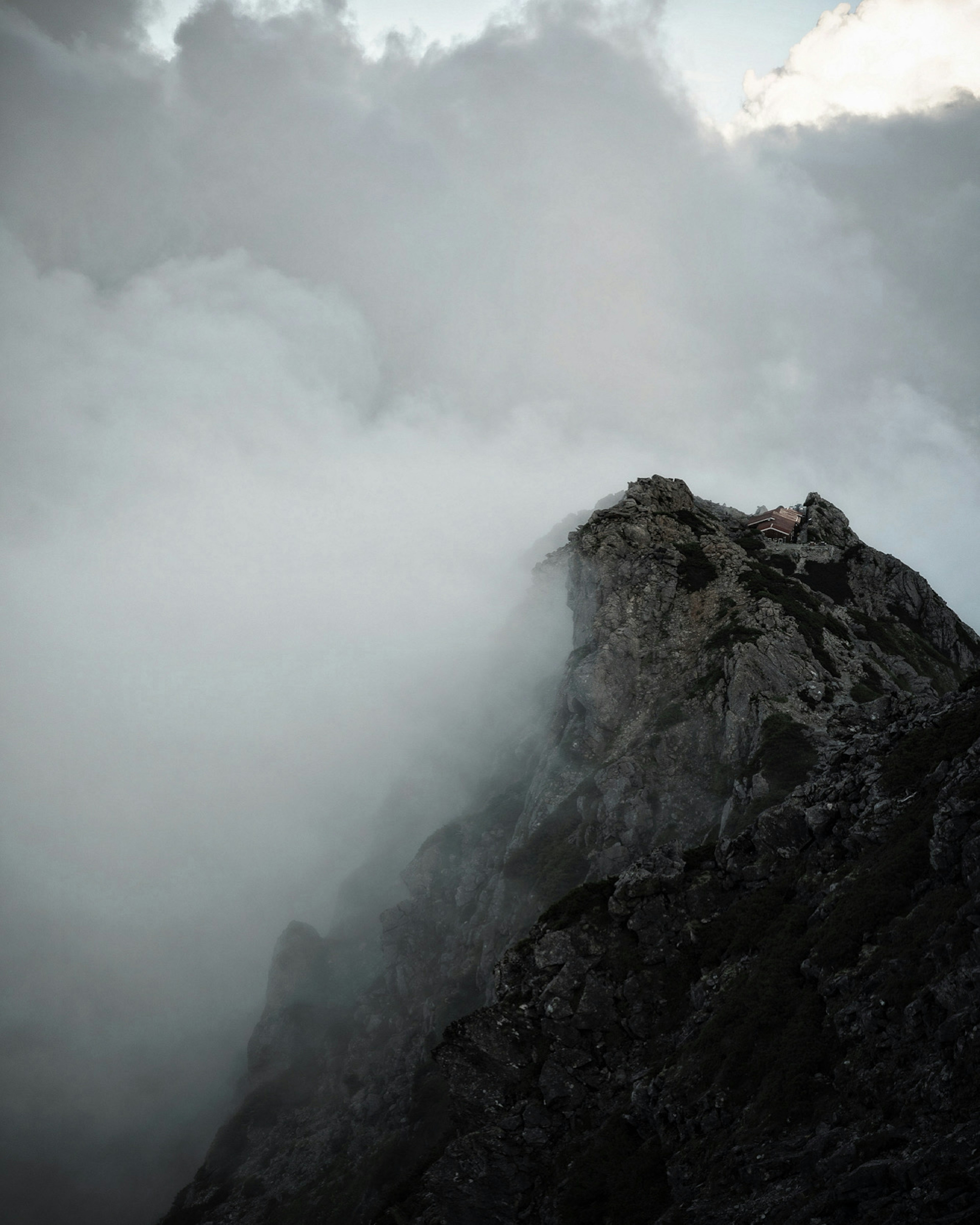 雲に覆われた山の頂上が見える風景