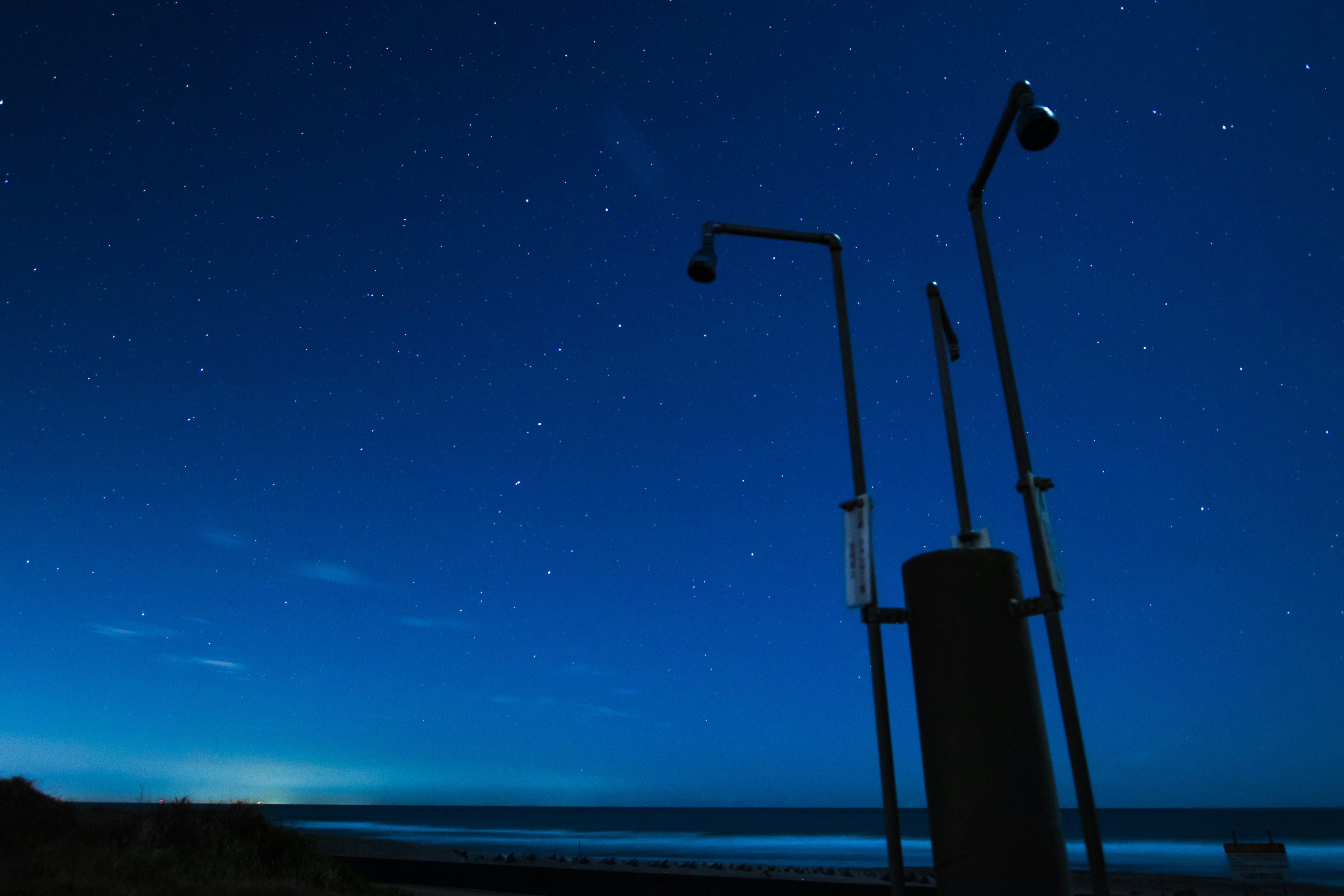 Équipement côtier silhouetté contre un ciel nocturne étoilé