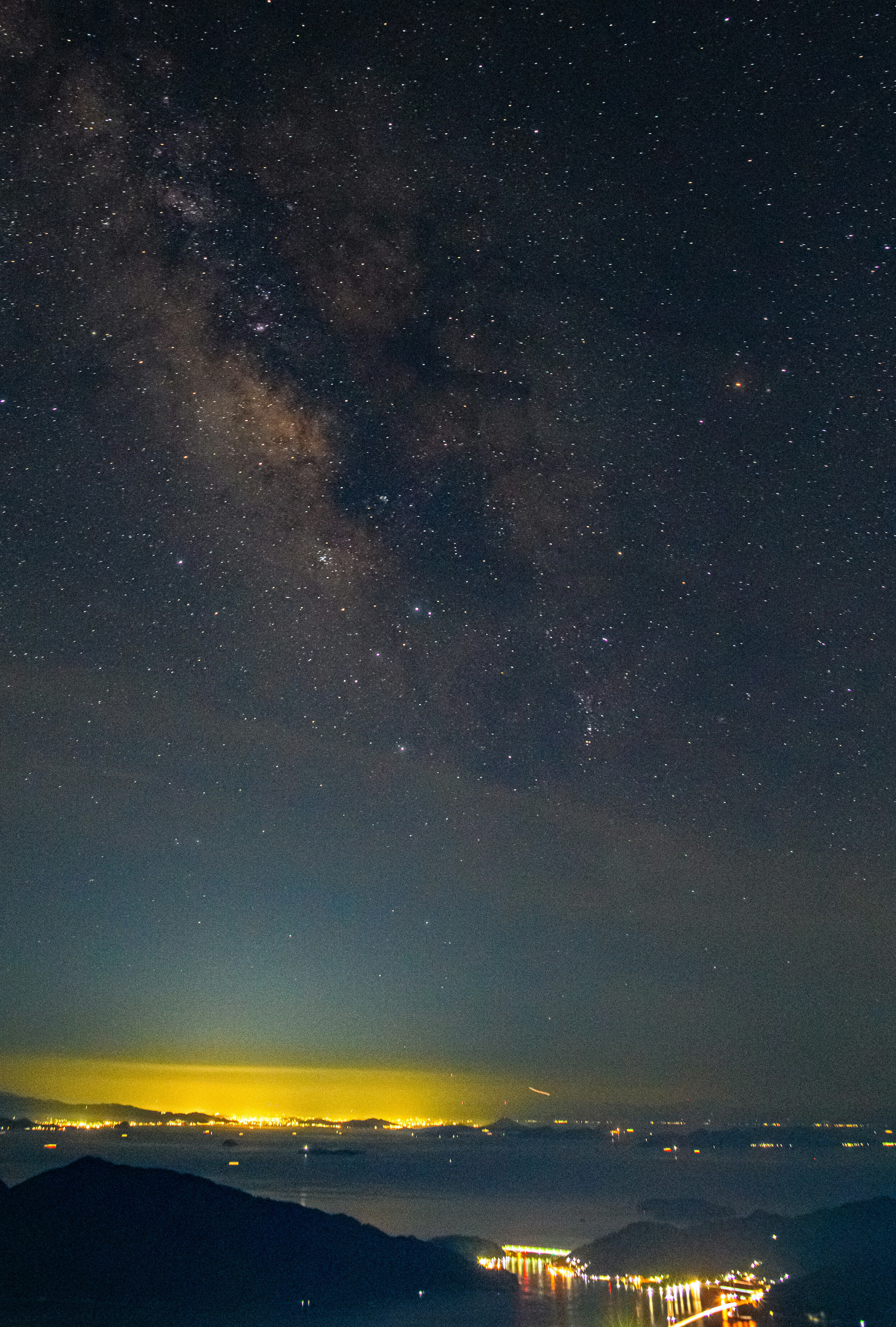 Pemandangan malam dengan Galaksi Bima Sakti dan danau tenang