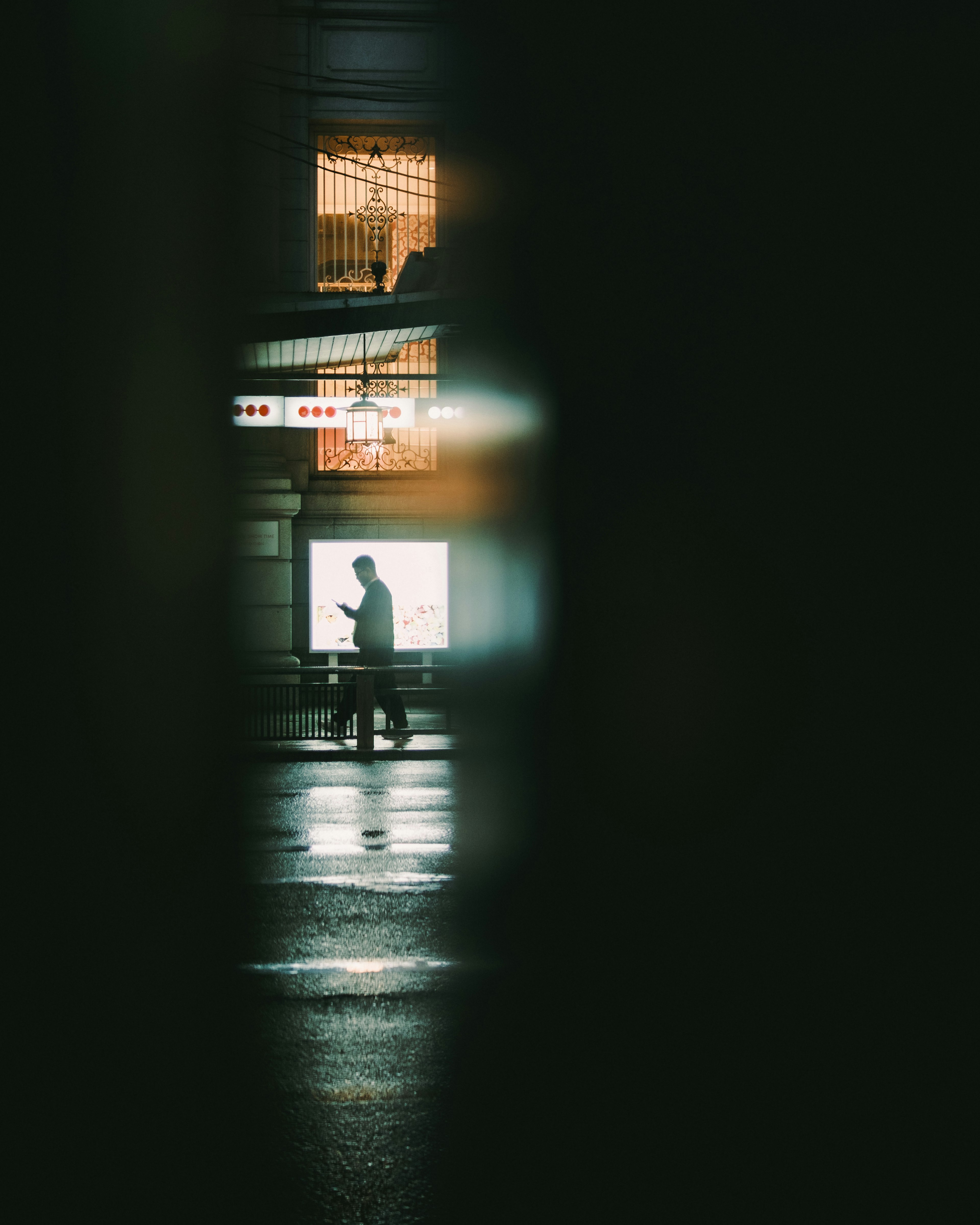 Silhouette of a person walking in a dark street with backlighting