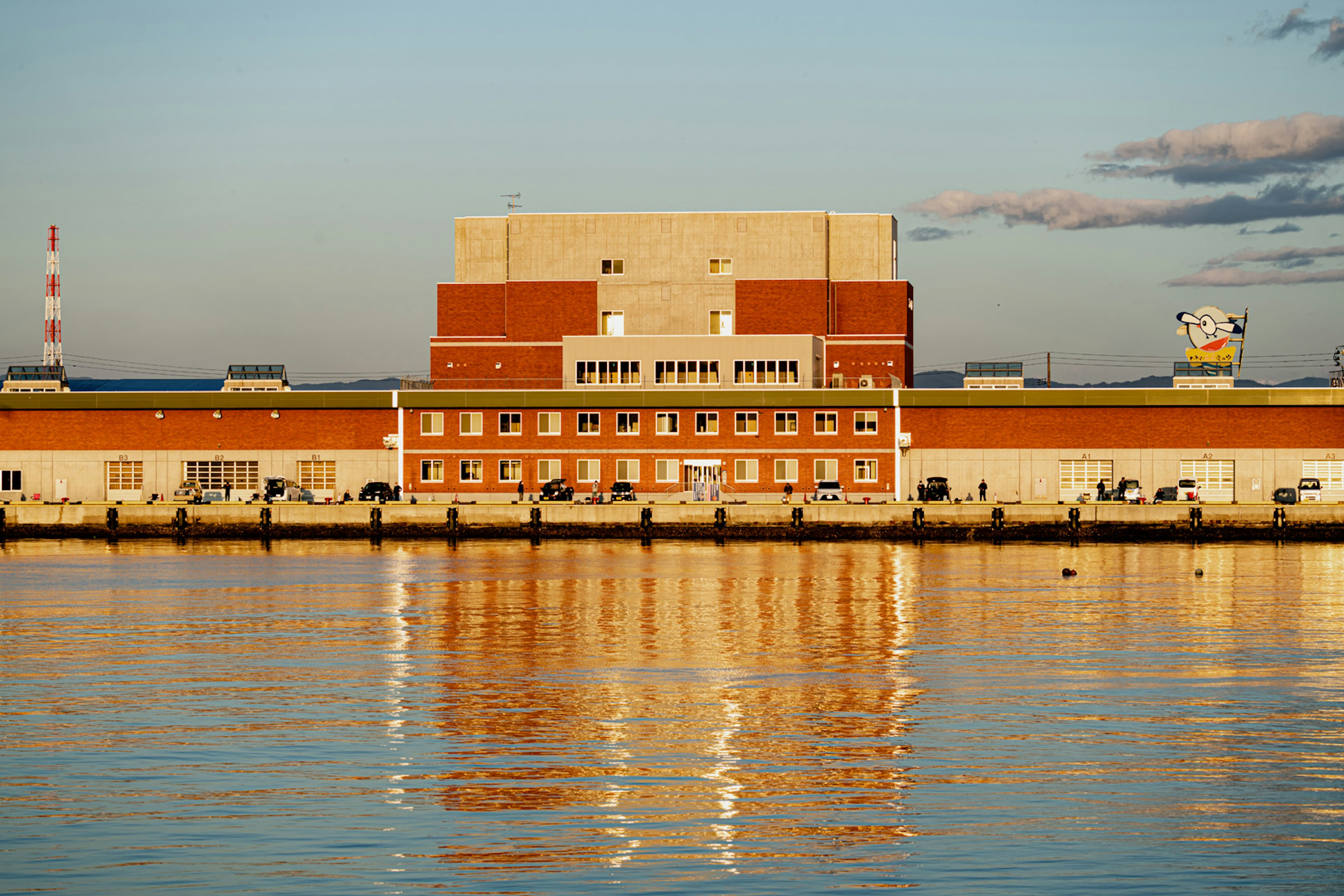 Reflection of a red building and industrial structures on water