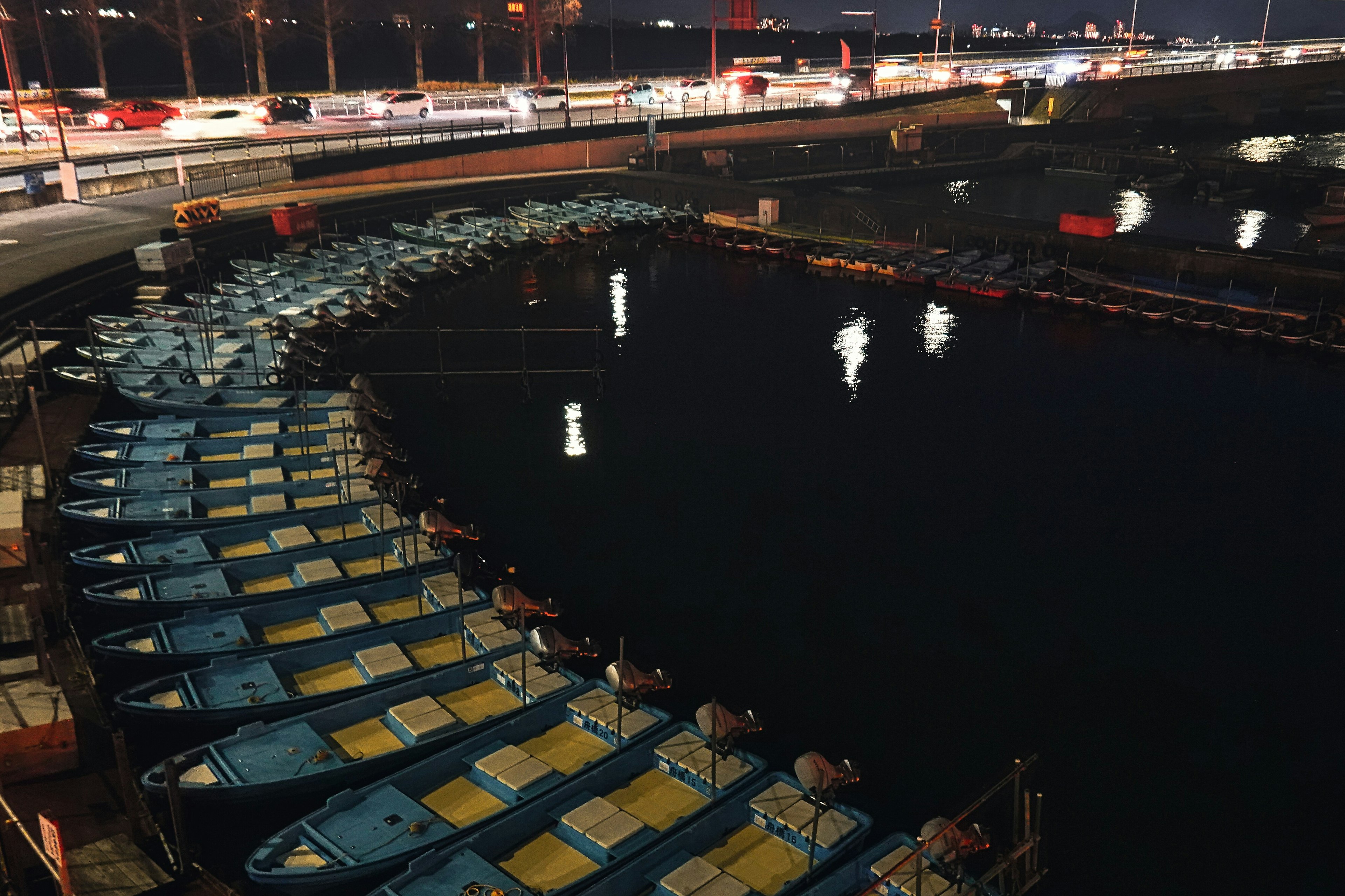 Groupe de bateaux bleus amarrés dans un port la nuit