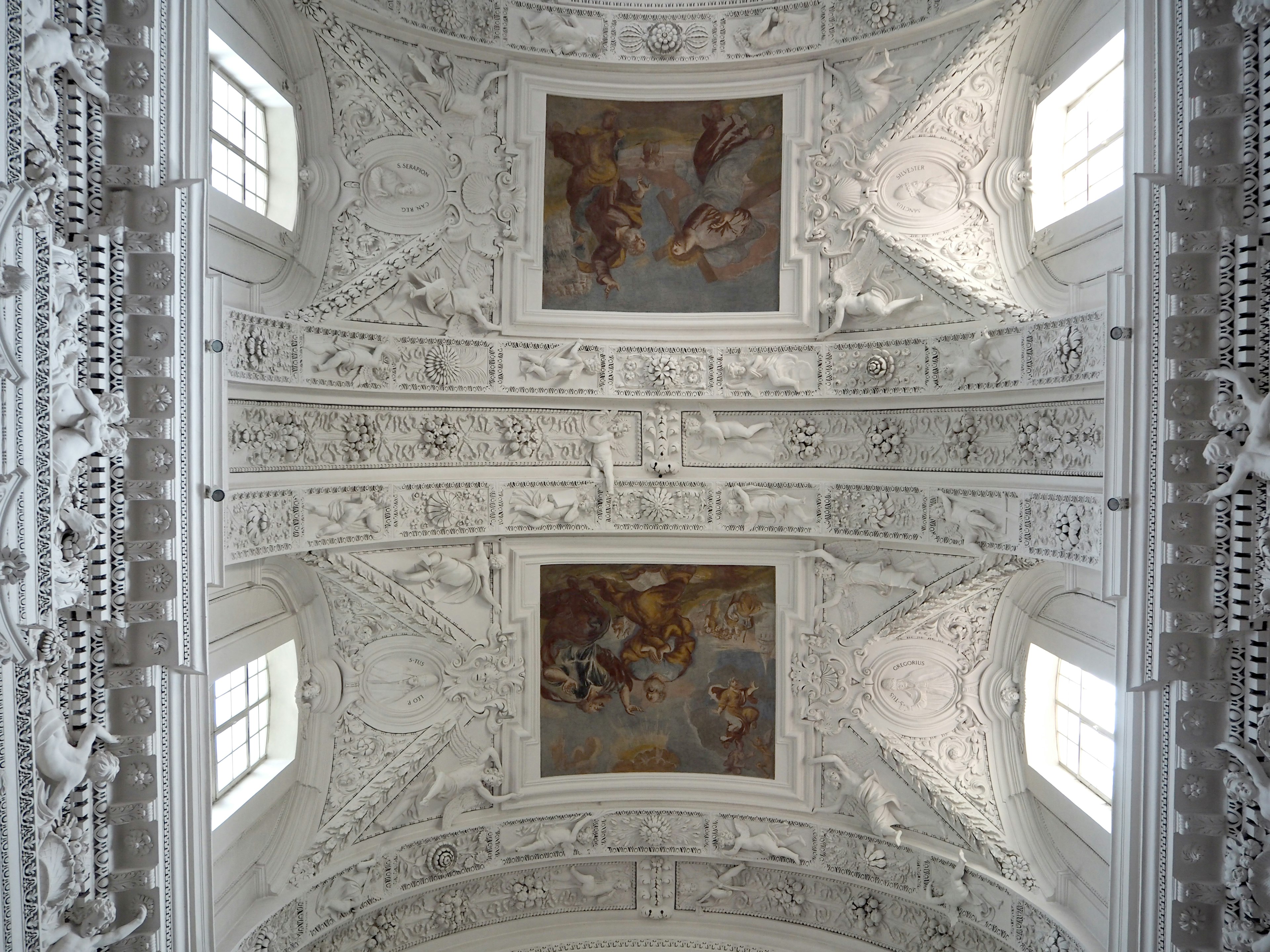 Decorative white ceiling with two ceiling paintings in interior view