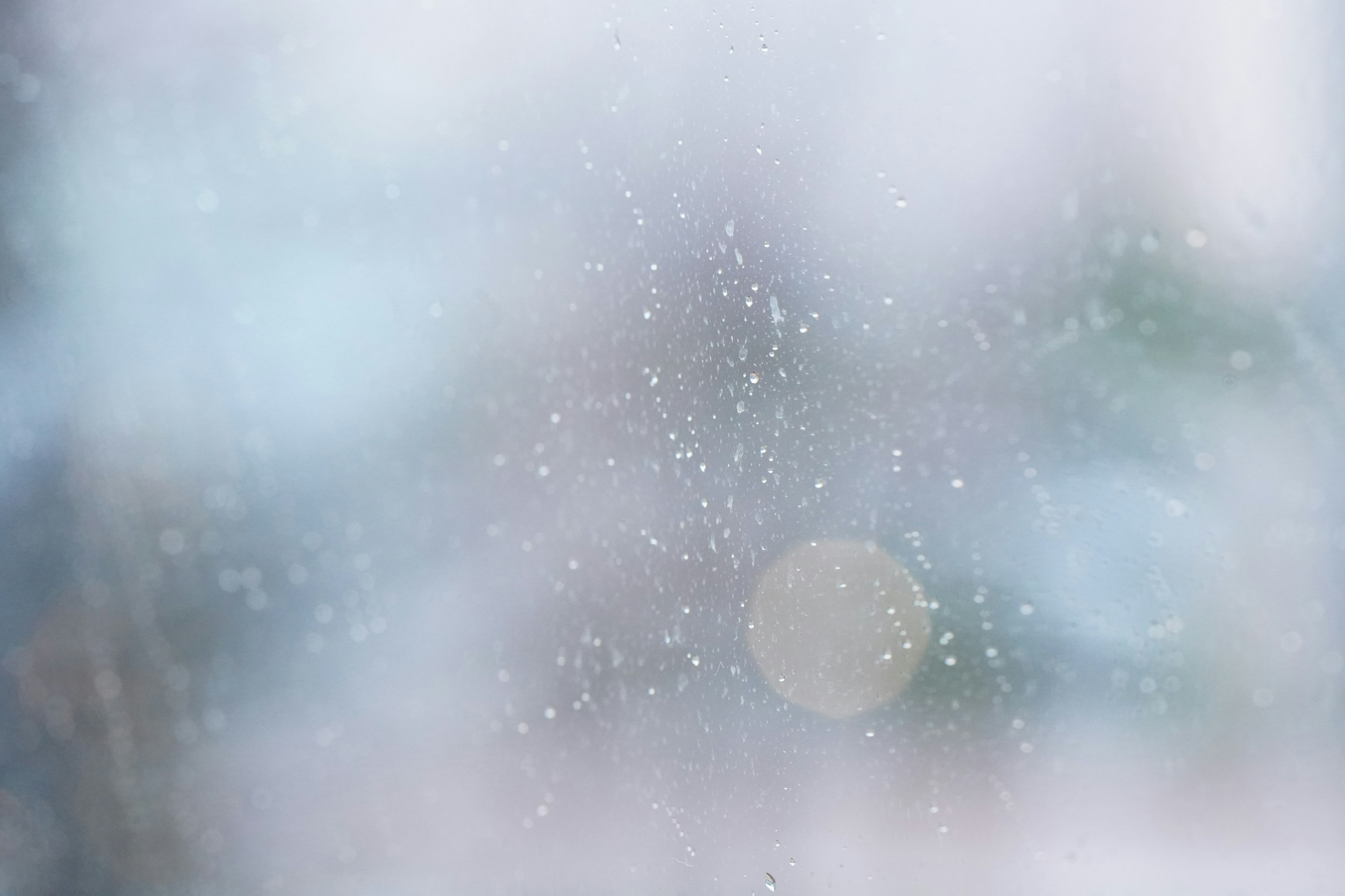 Primer plano de una ventana con gotas de agua y fondo borroso