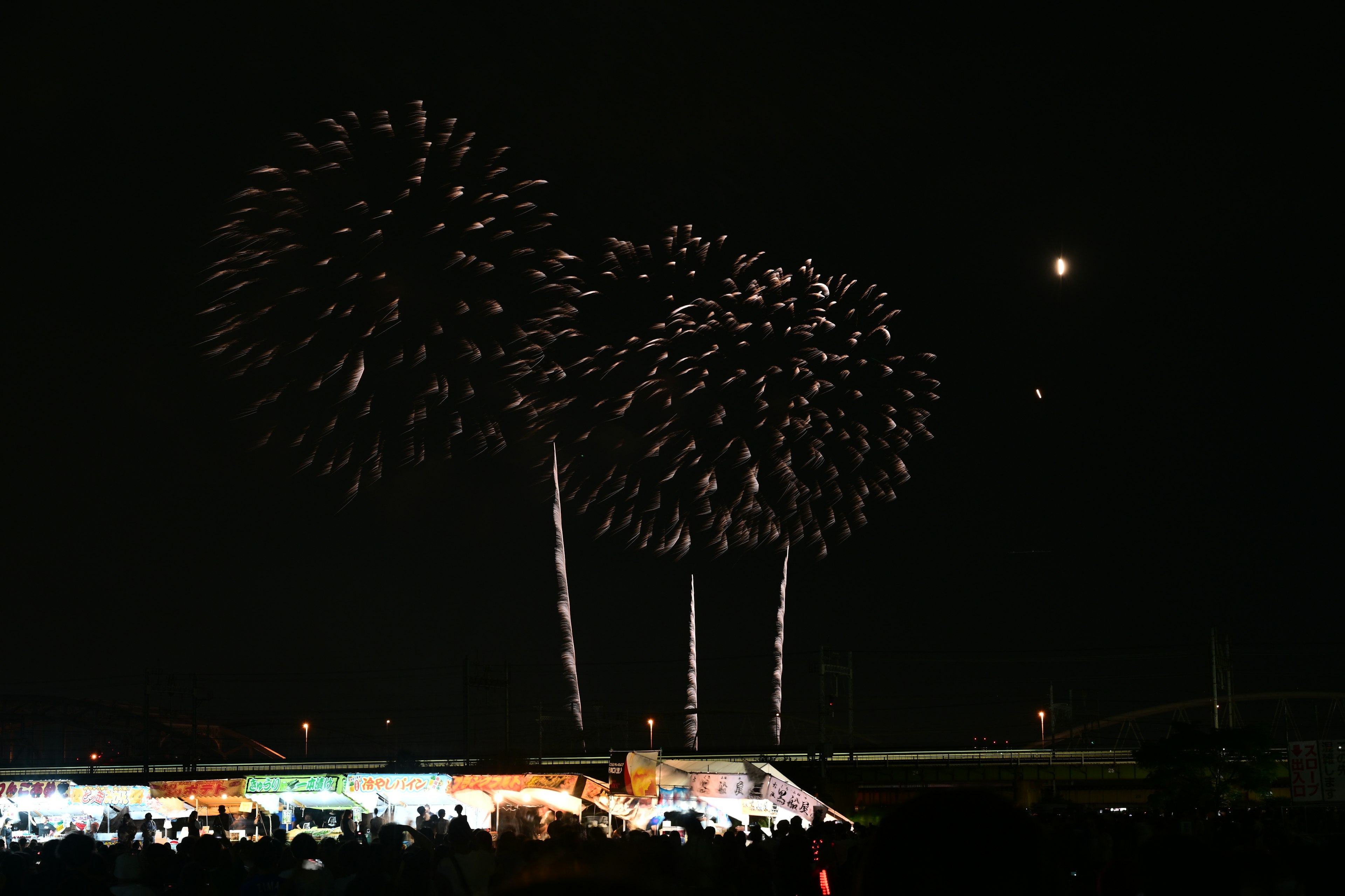 夜空に輝く花火と観客のシルエット