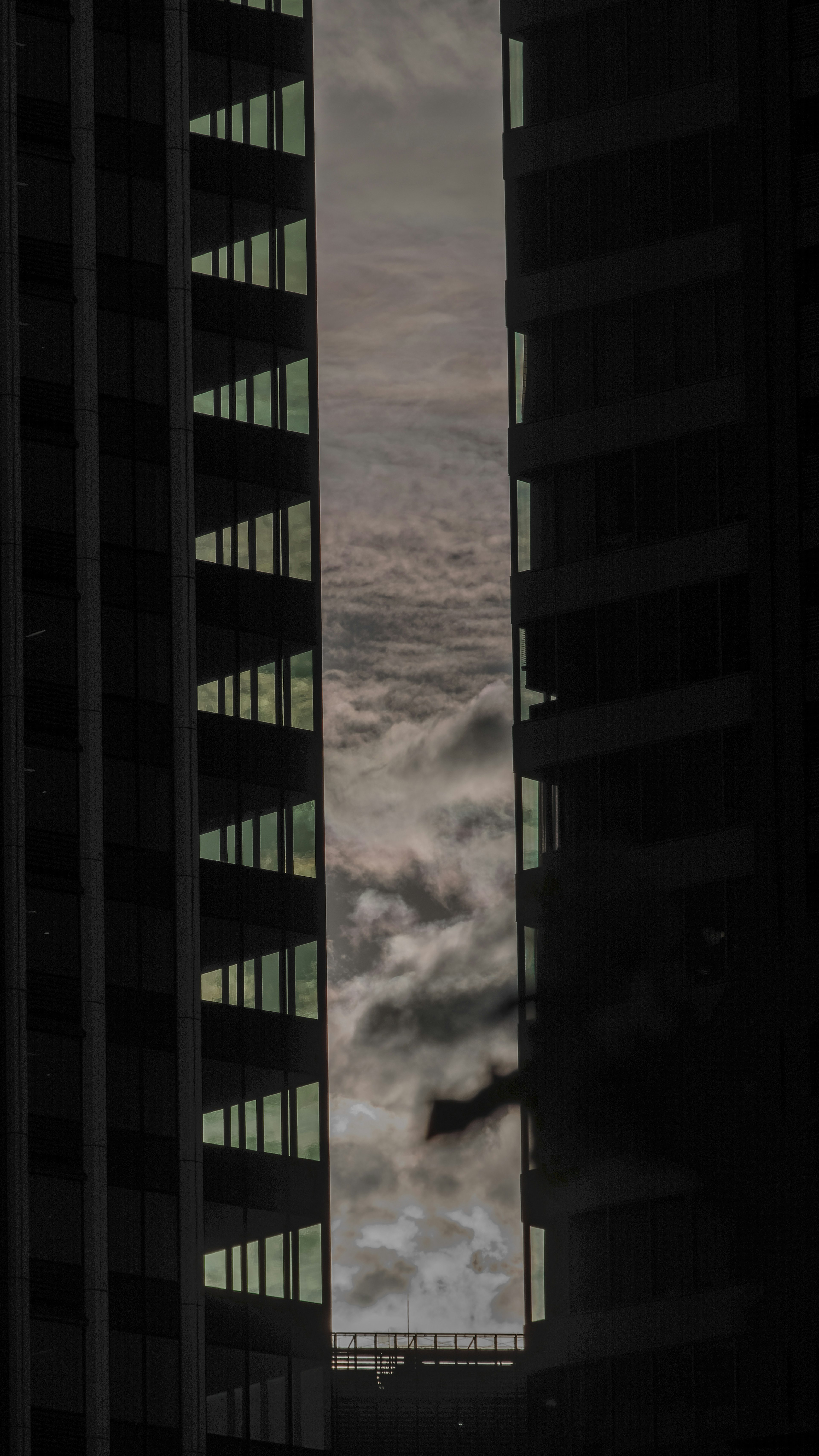 Clouds visible between two tall buildings