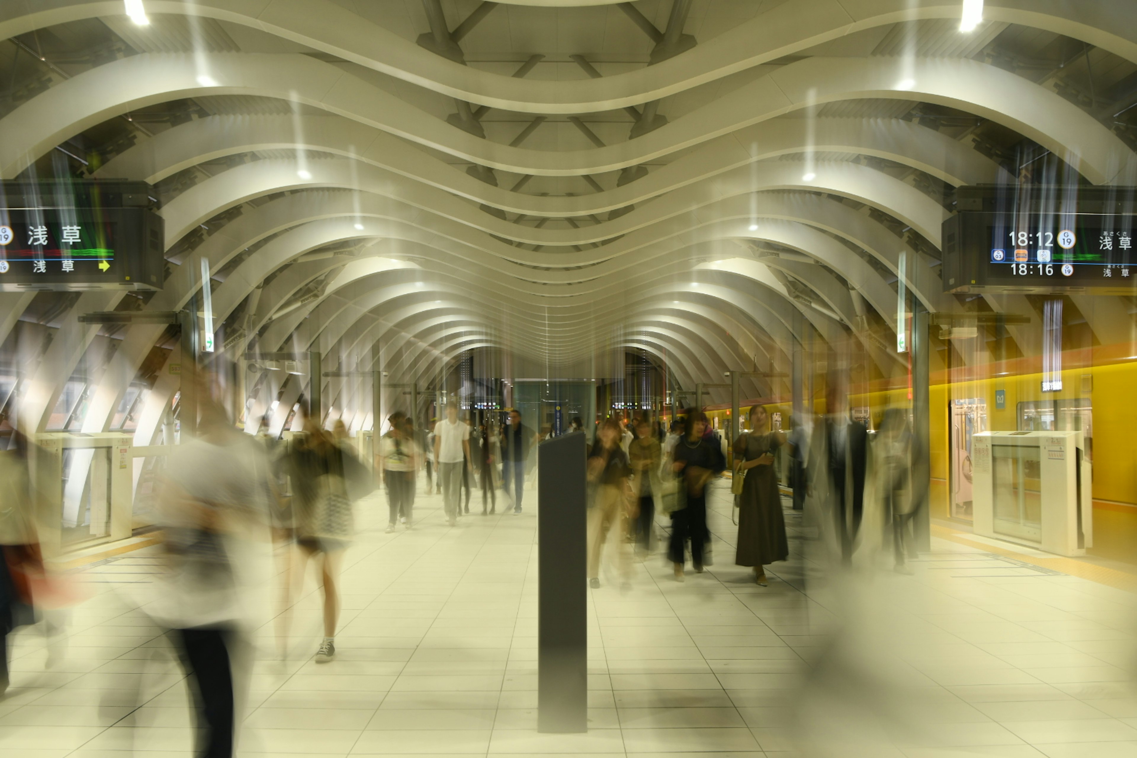 Blurred image of a busy train station corridor with people walking