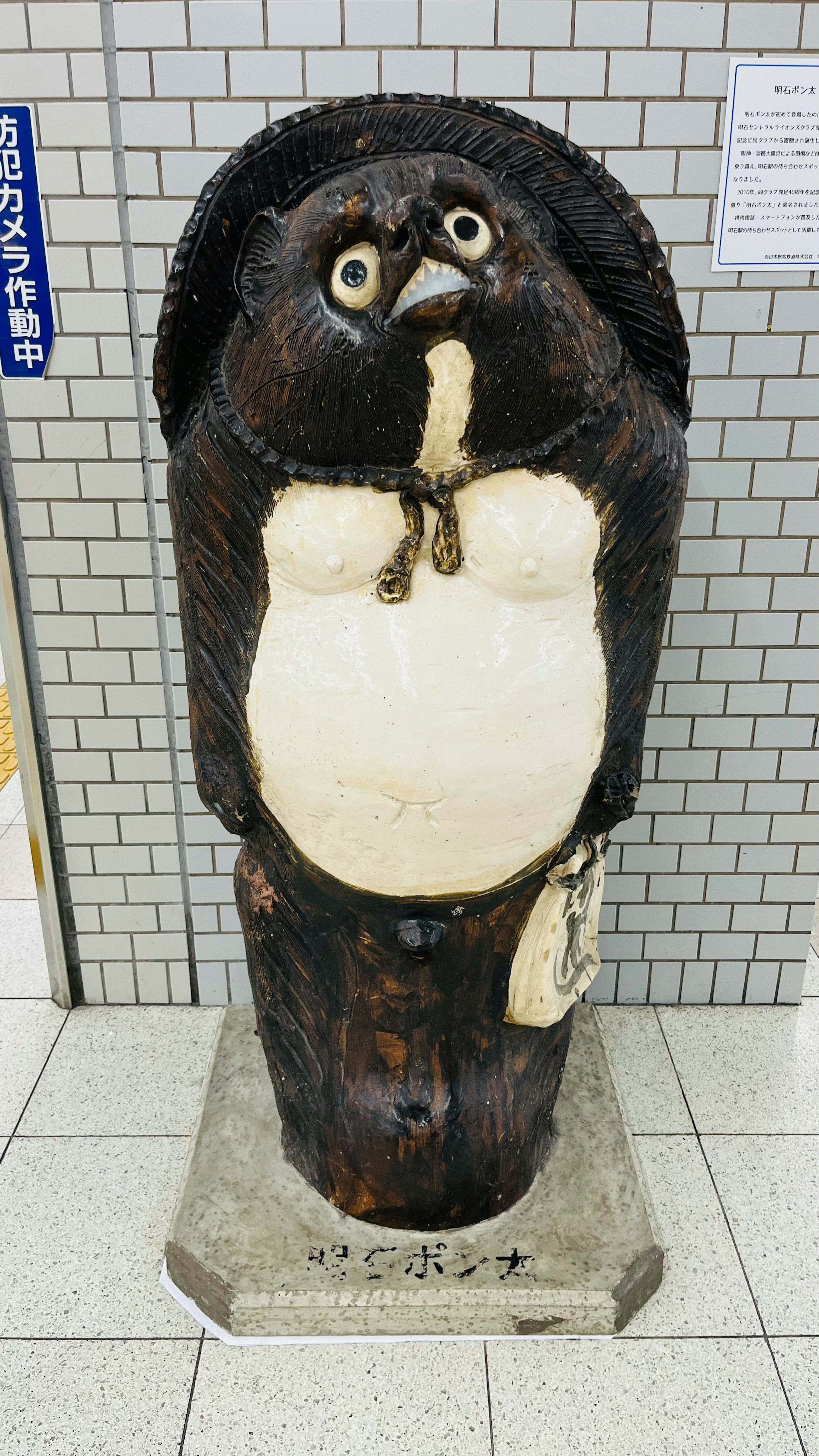 黒い狸の像が立っている駅の内部