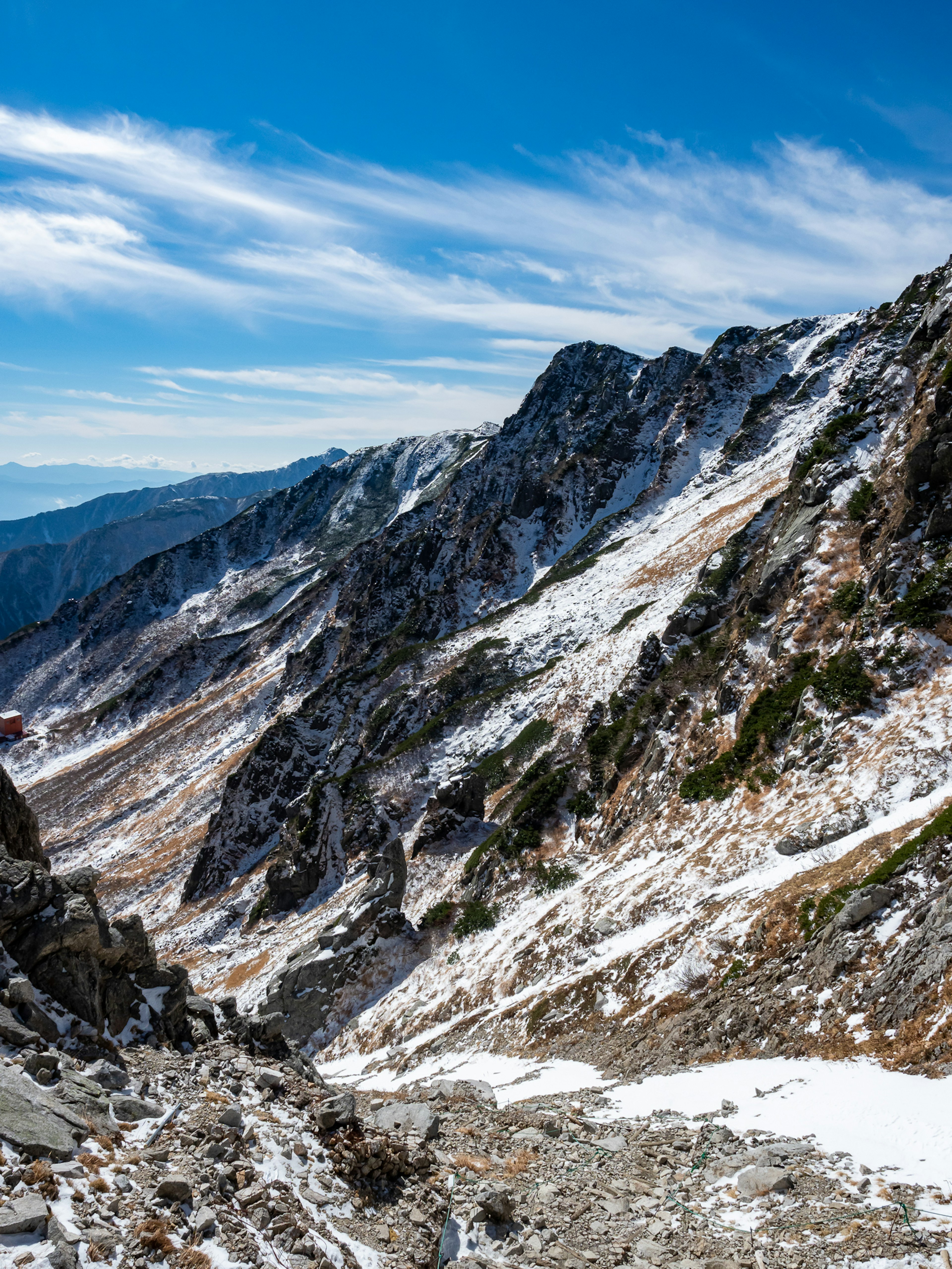 雪が残る山の斜面と青空の風景