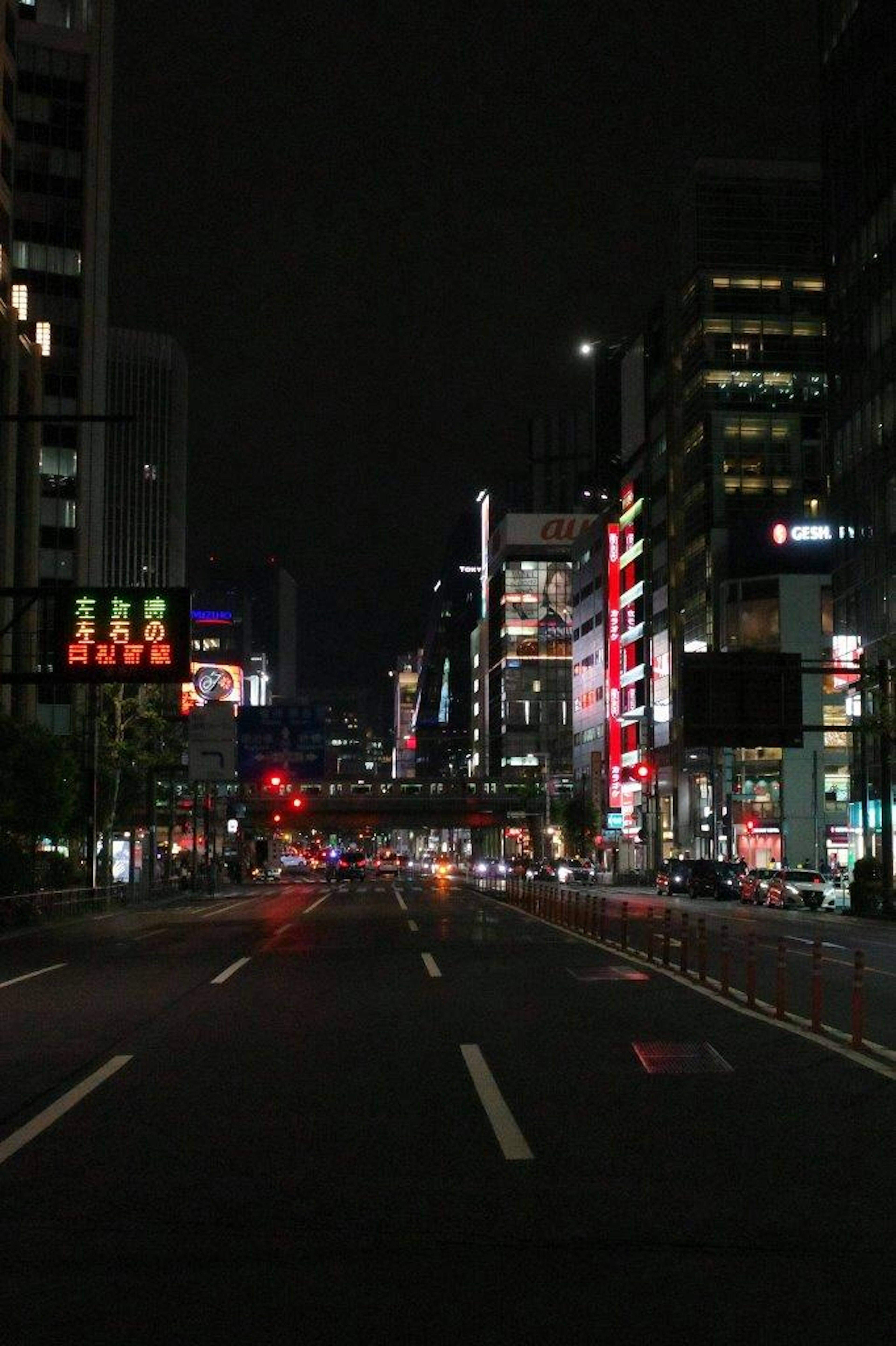 夜の都市の道路に並ぶビルとネオンの看板