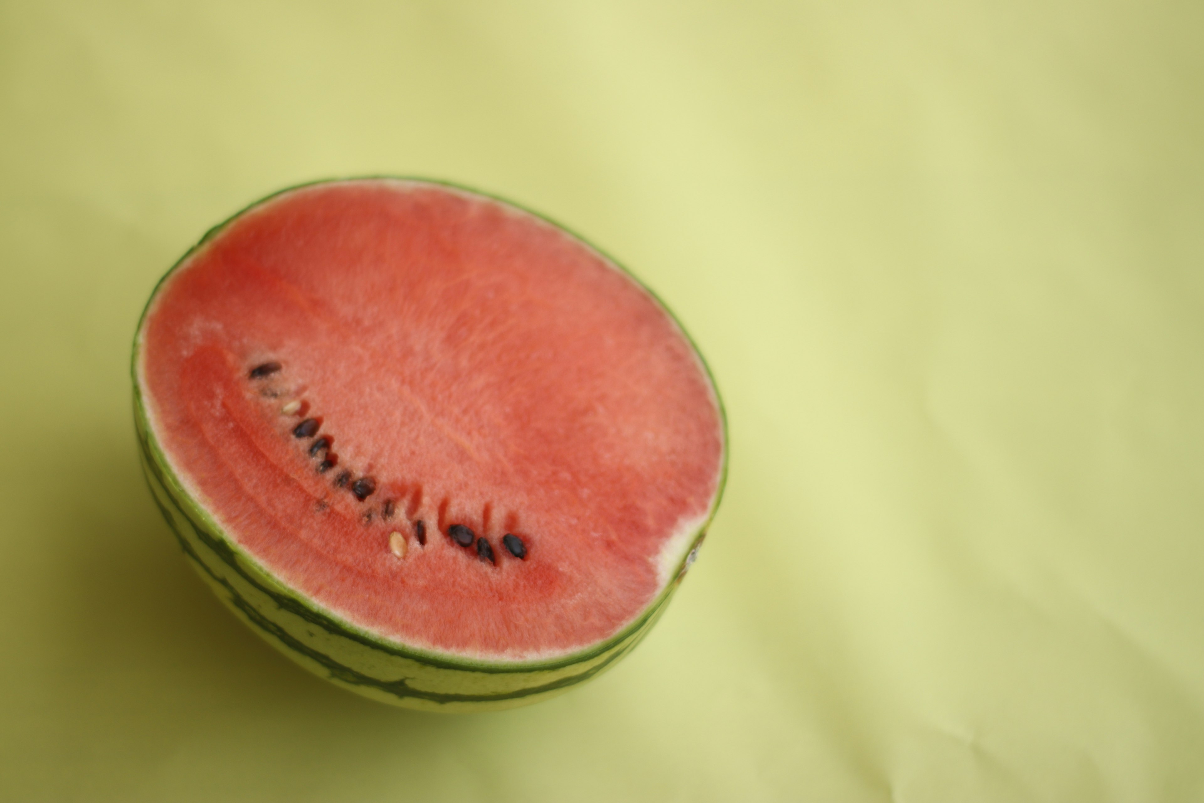 Hälfte einer Wassermelone mit leuchtendem rotem Fruchtfleisch und grüner Schale