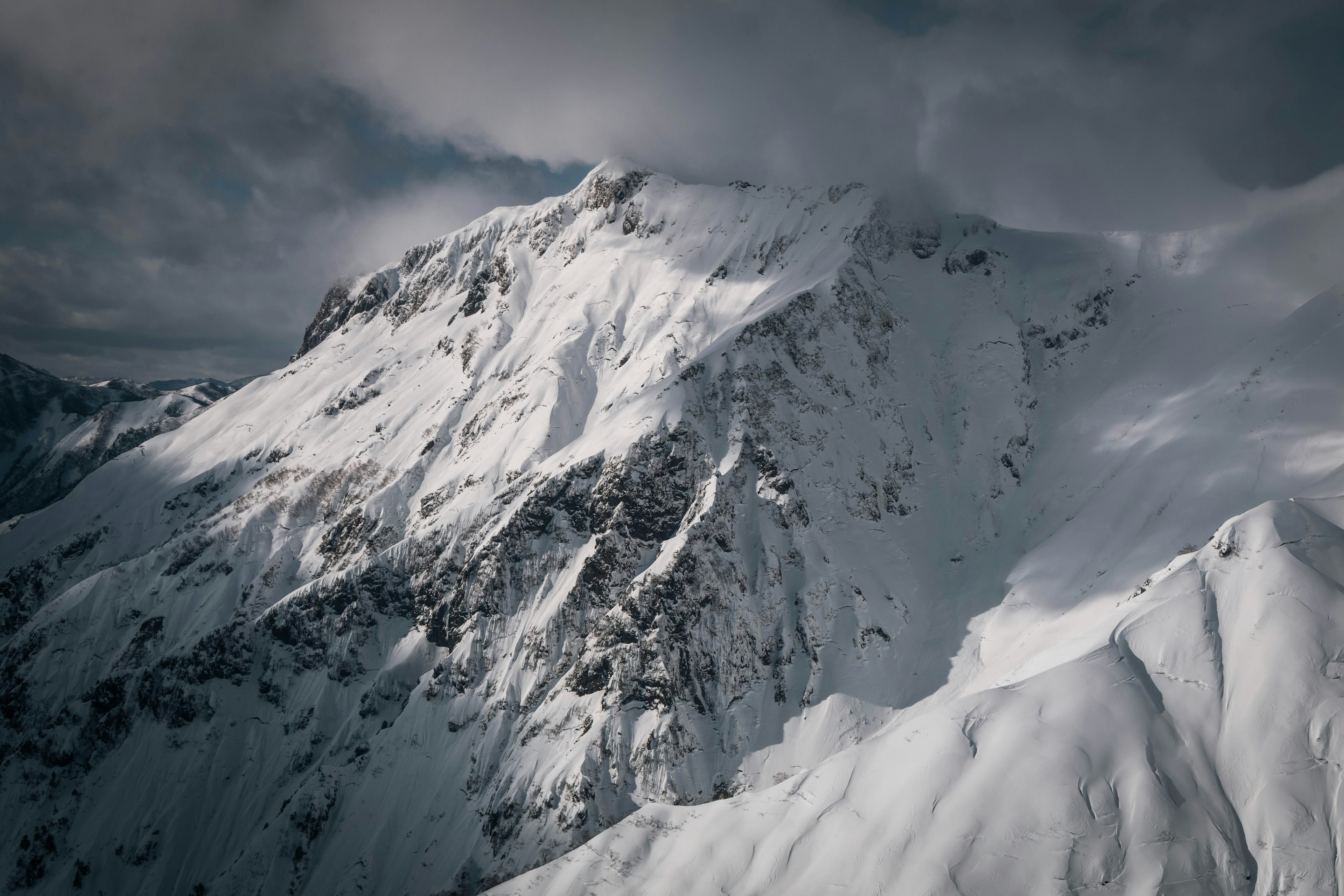 Paisaje montañoso cubierto de nieve con nubes