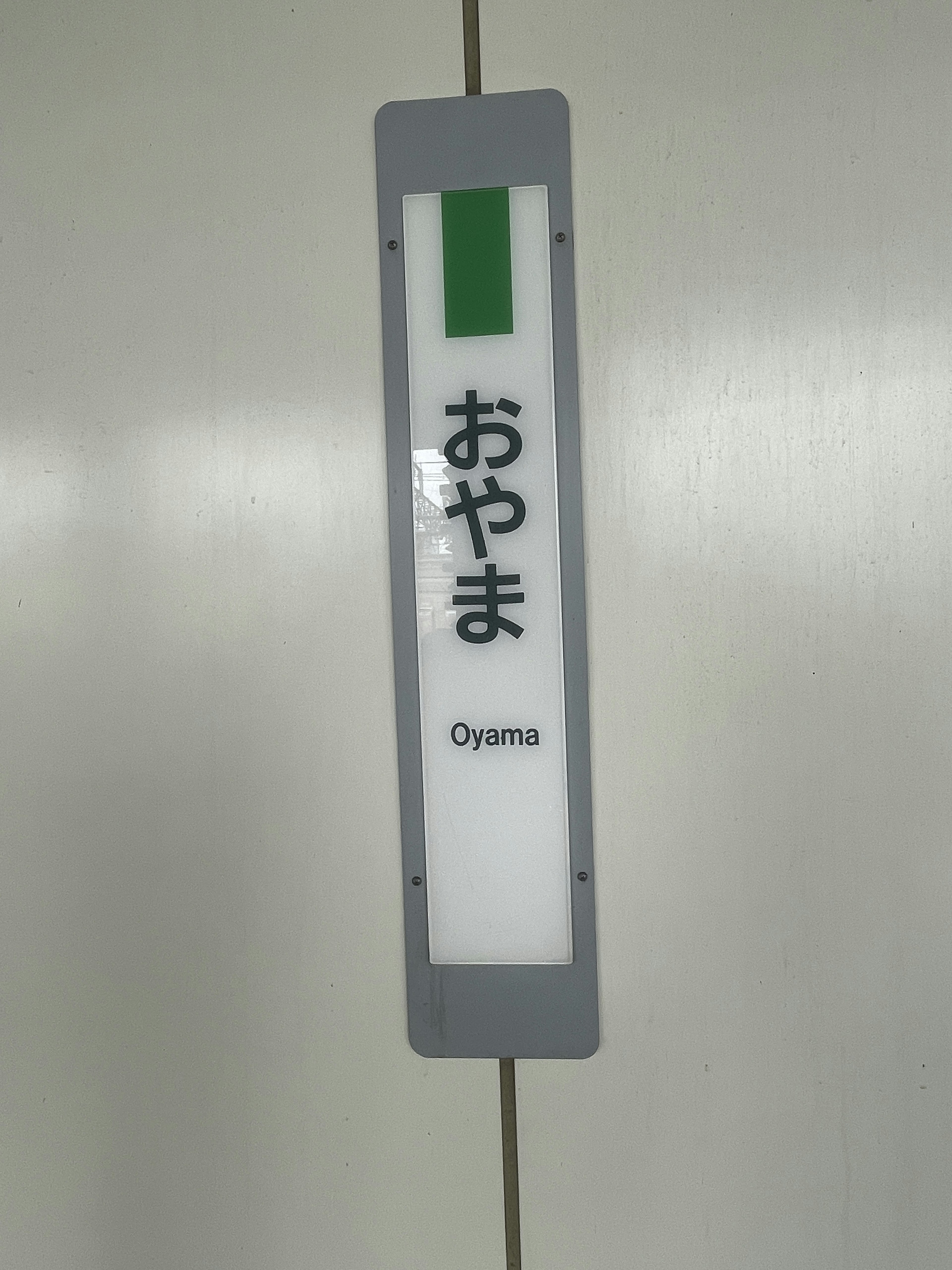 Oyama station sign with green design