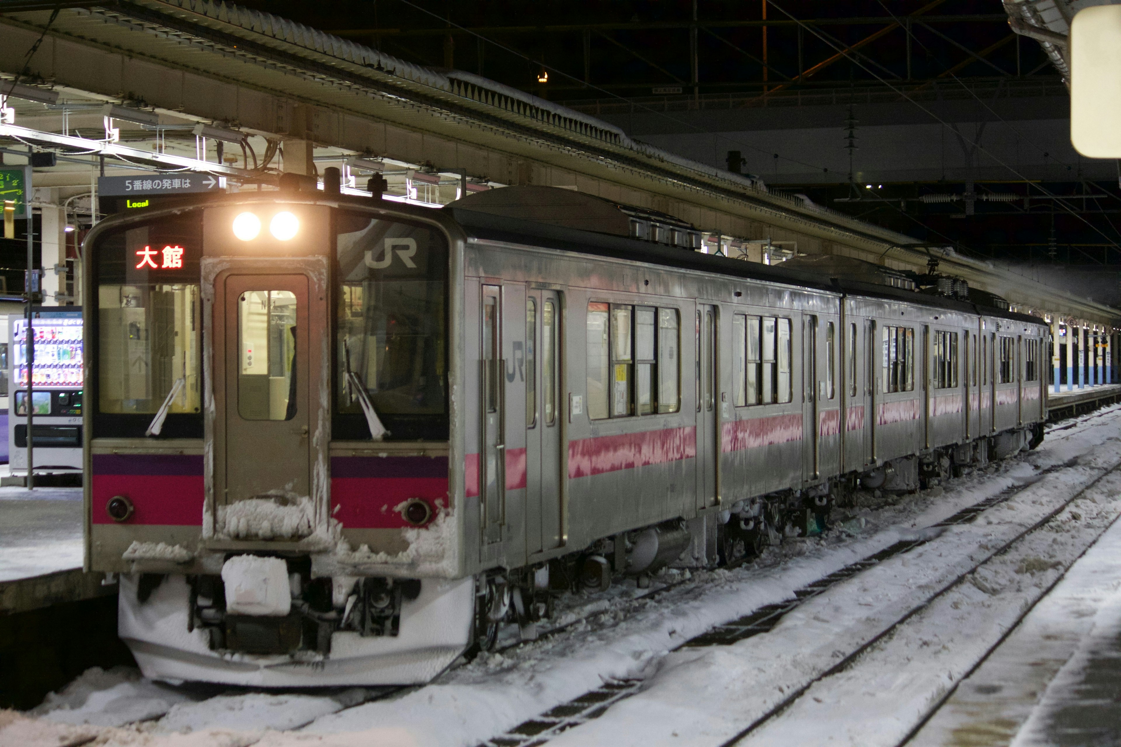 雪の中に停車しているJRの列車とホームの風景