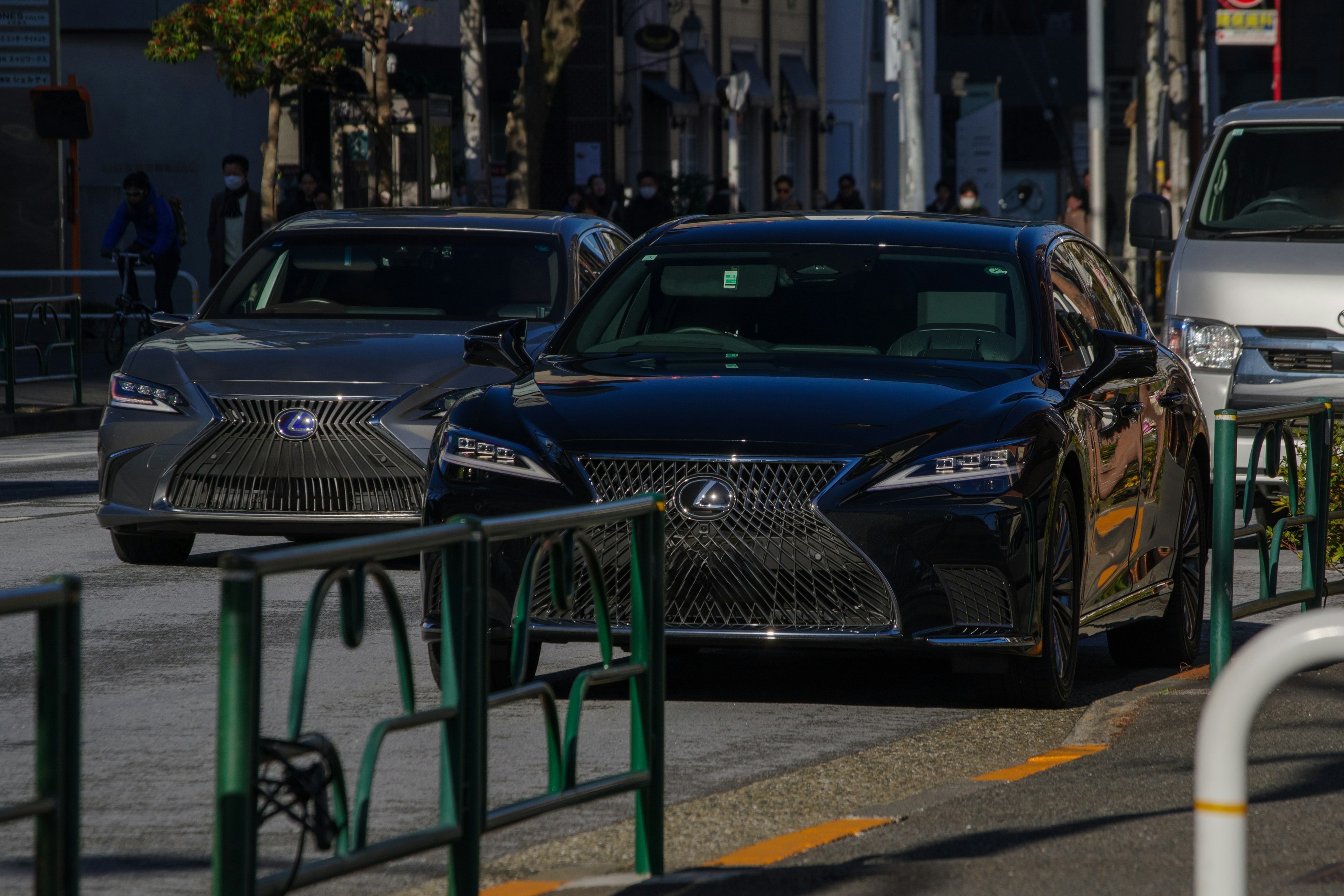 Black and silver Lexus cars on a city street