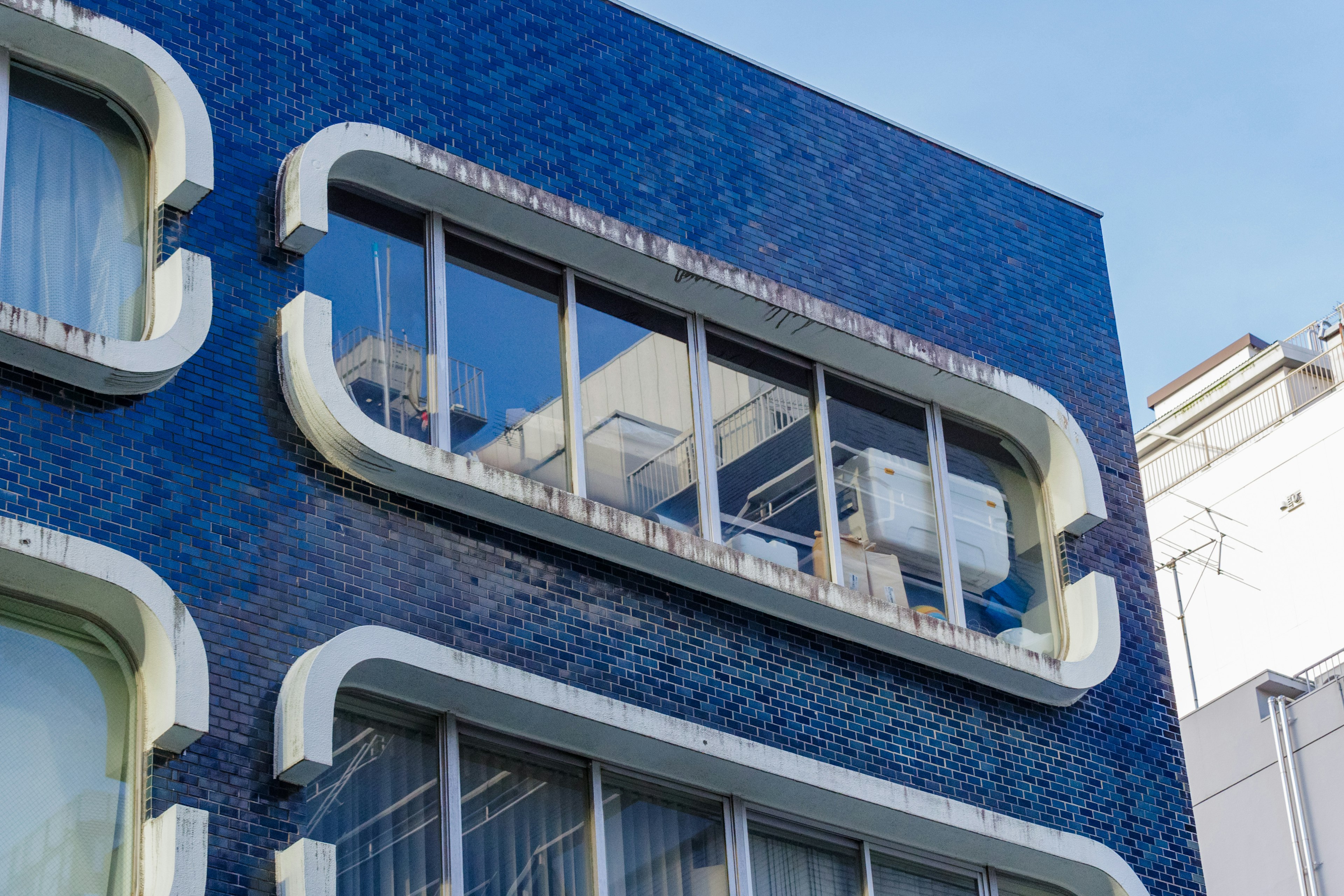 Modern building with blue exterior featuring large windows and balconies