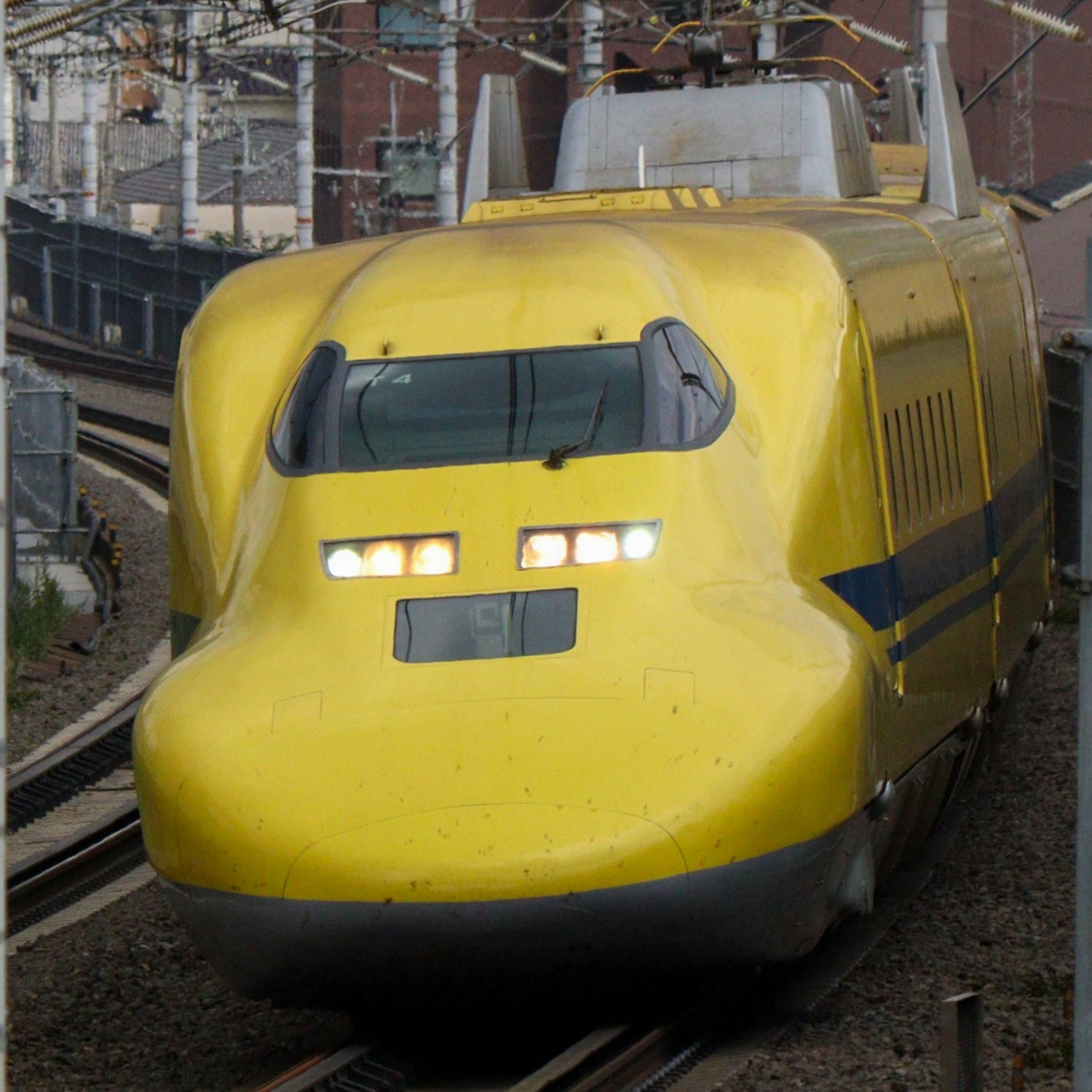 Yellow Shinkansen train approaching on the tracks